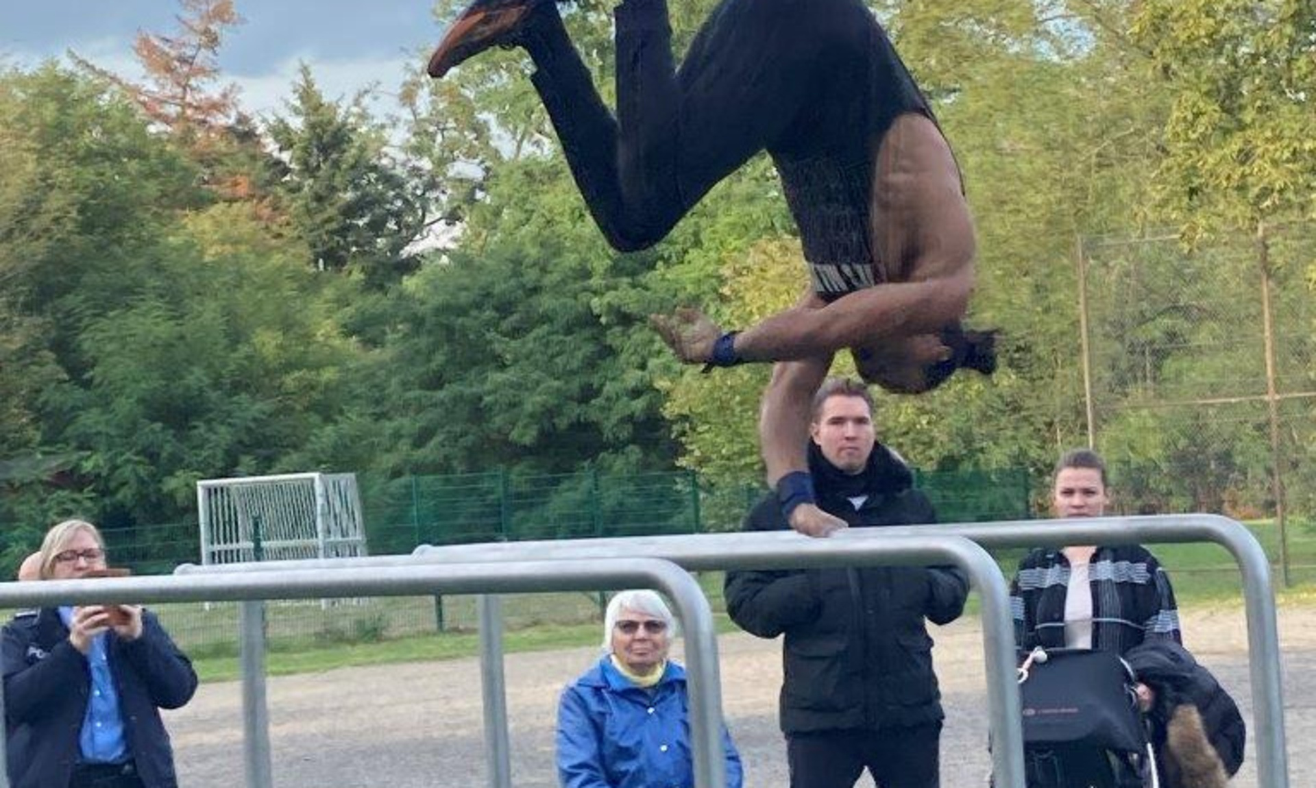Mann macht Salto an Fitnessgerät