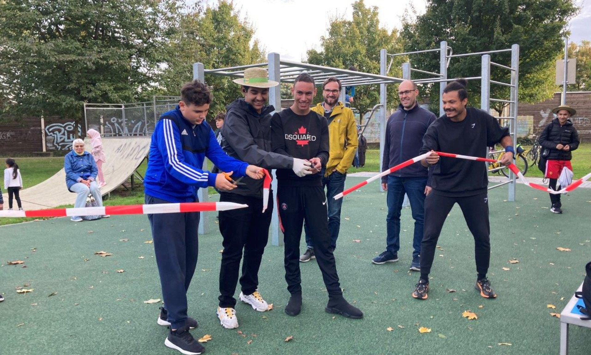 Sechs Männer schneiden Baustellenband durch