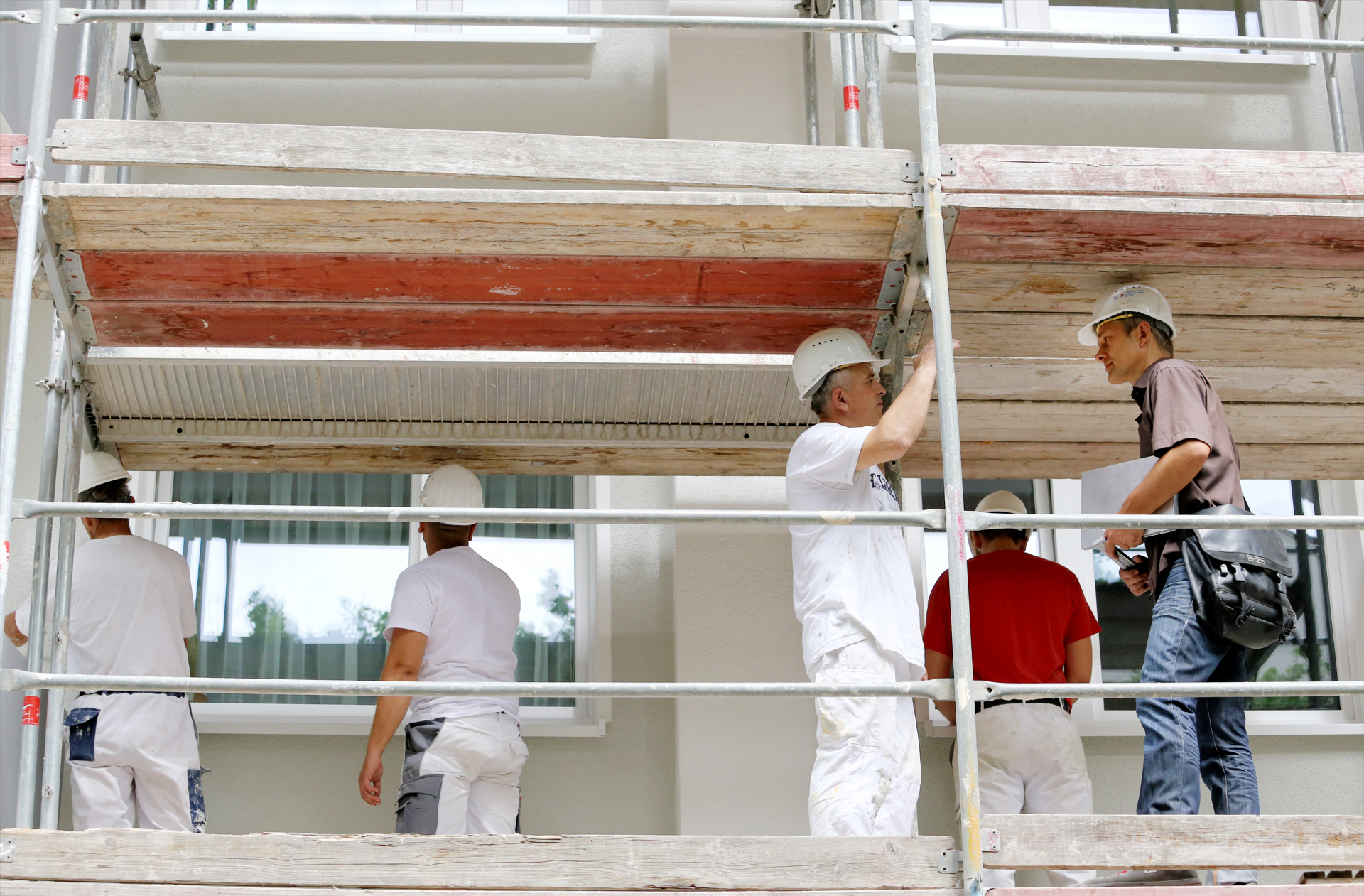 Projektleiter mit Bauarbeiter auf Baugerüst