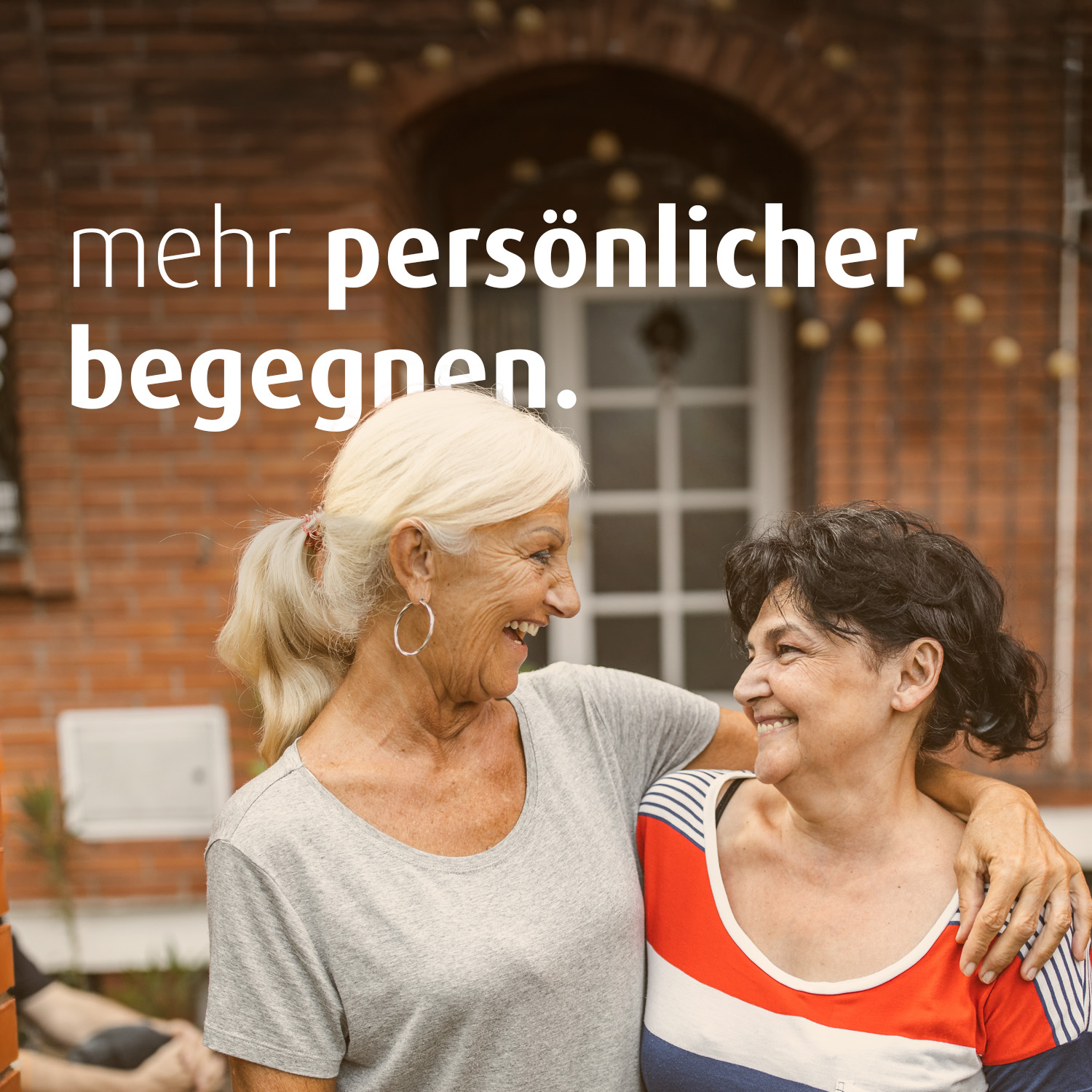 Zwei Frauen stehen nebeneinander und halten sich im Arm. Auf dem Bild steht der Text "mehr persönlicher begegnen".