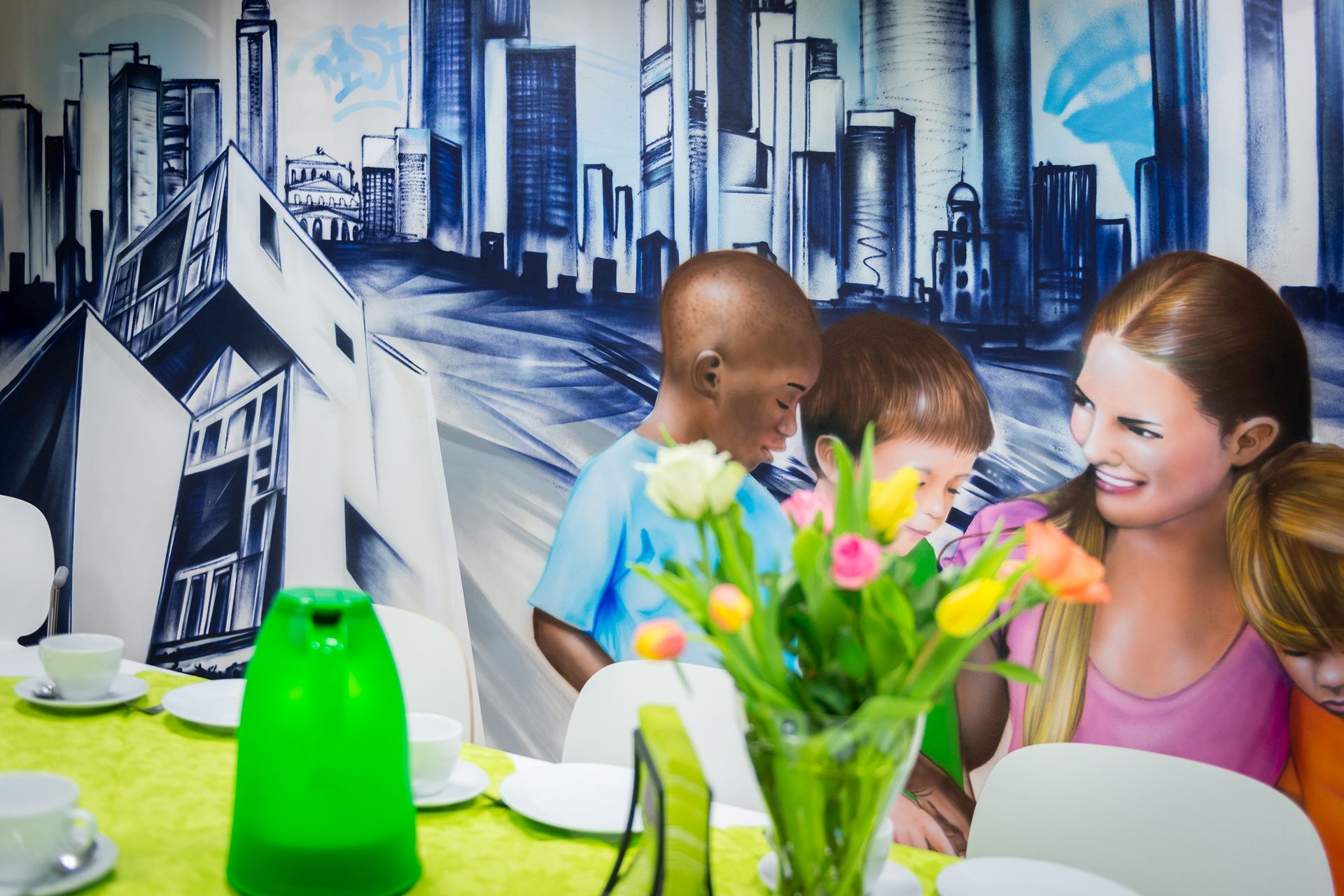 Raum mit Graffiti an der Wand, davor ein gedeckter Tisch.