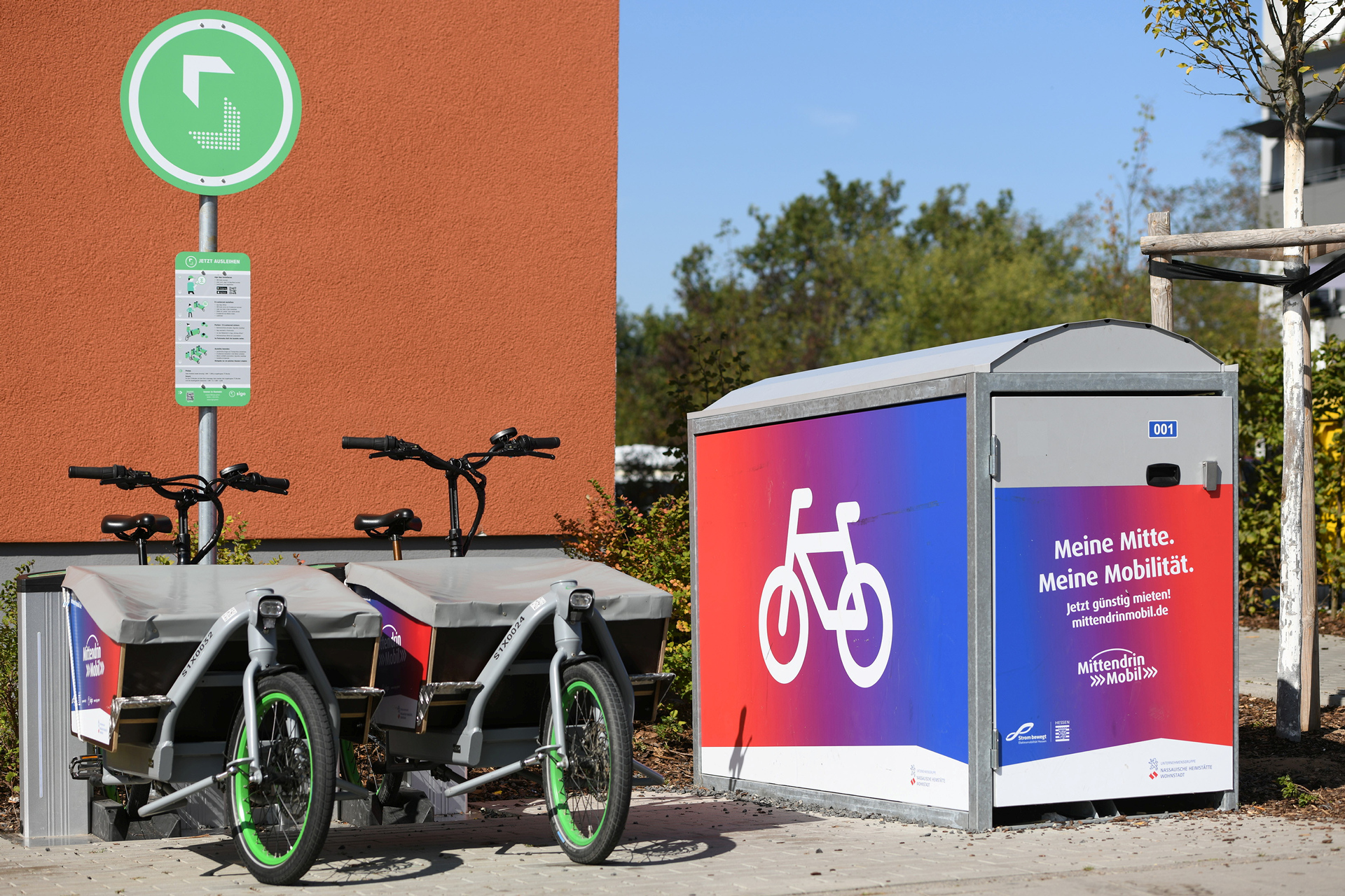 Fahrradbox und zwei geparkte Lastenräder.