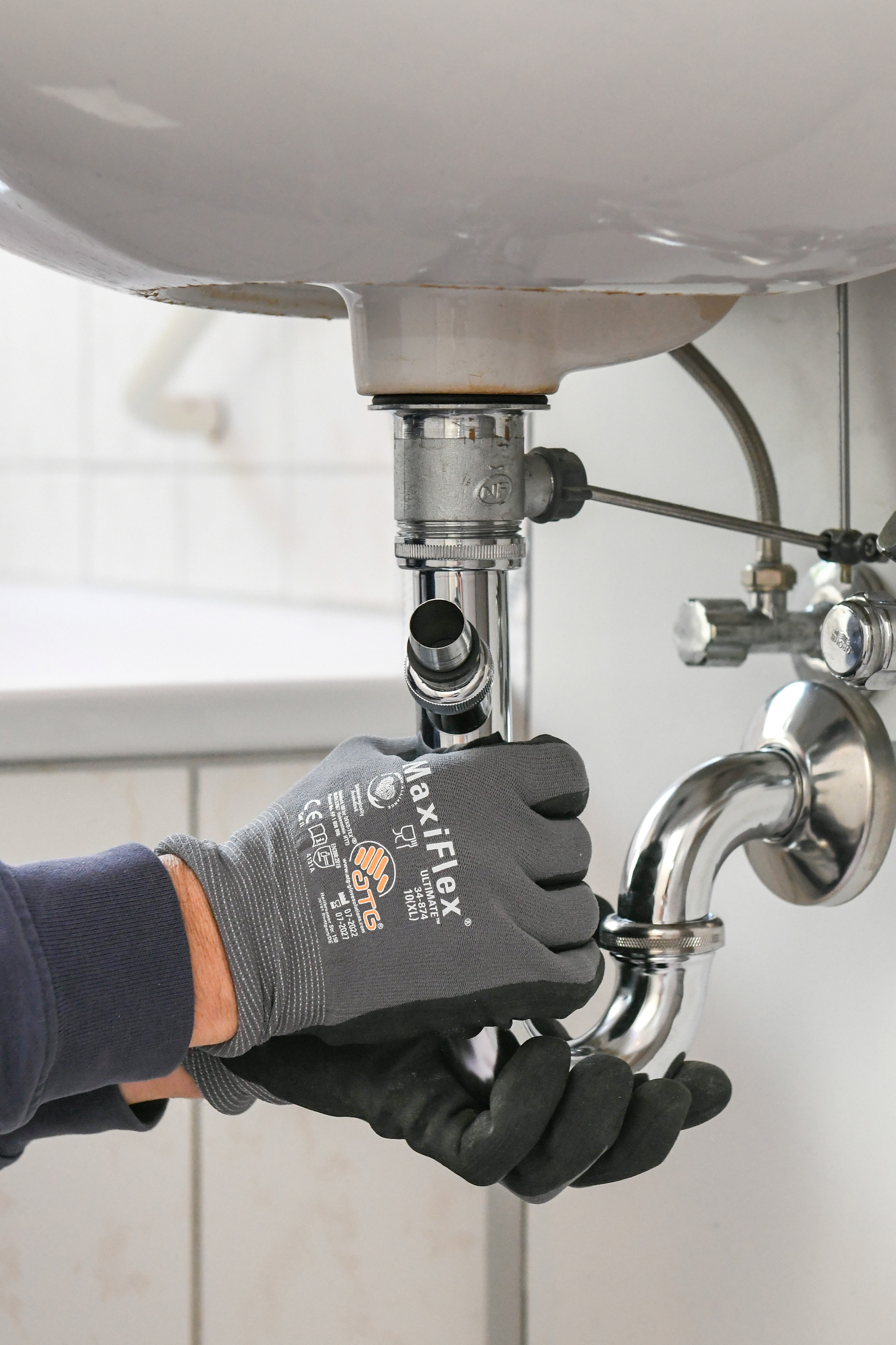 Handwerker repariert Abflussrohr am Waschbecken.