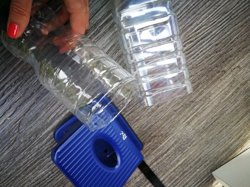 PET-Flaschen und Locher liegen auf einem Tisch.