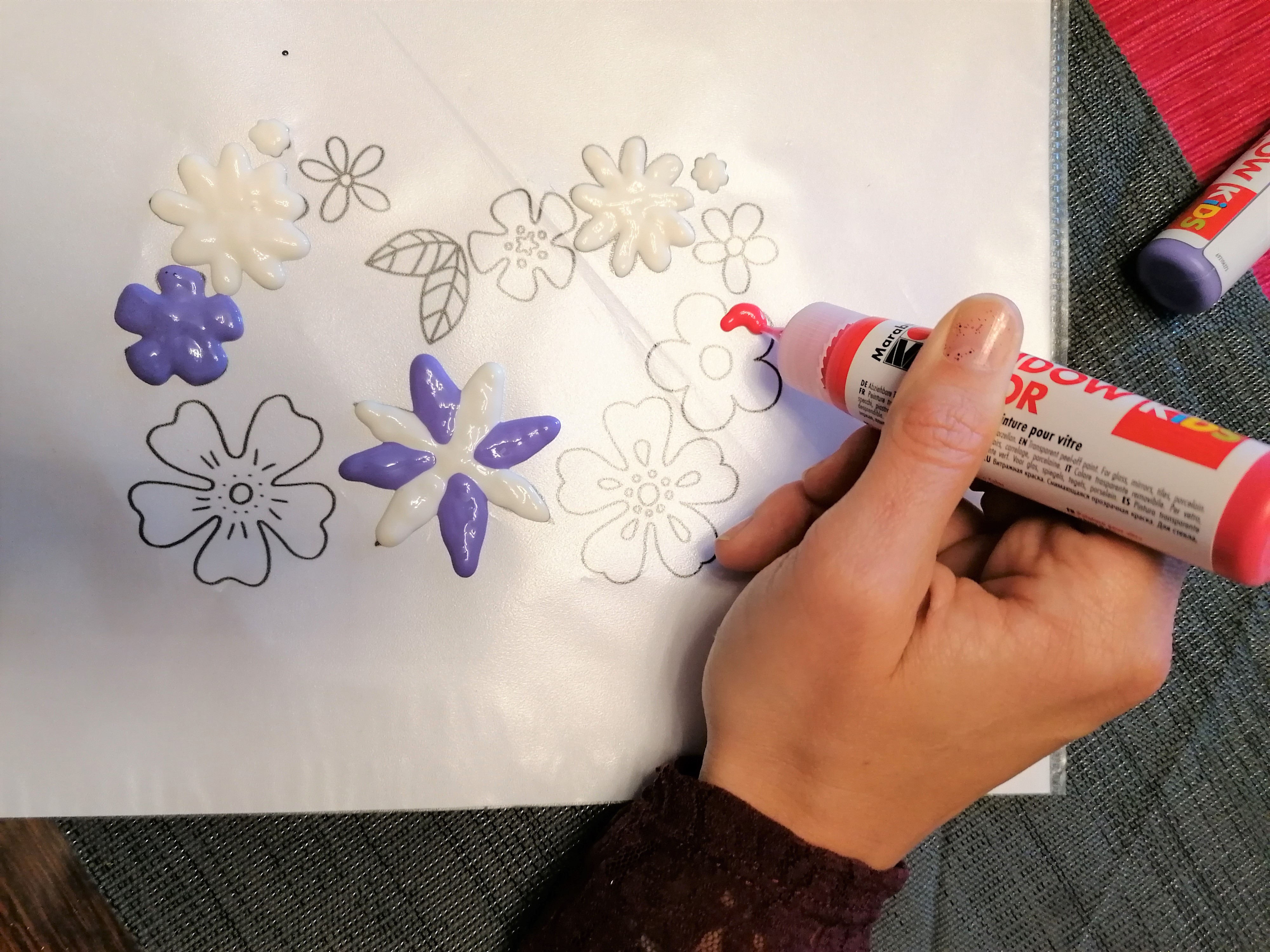 Eine Malvorlage mit Blumenmotiv wird mit Windowcolor auf eine Folie übertragen.