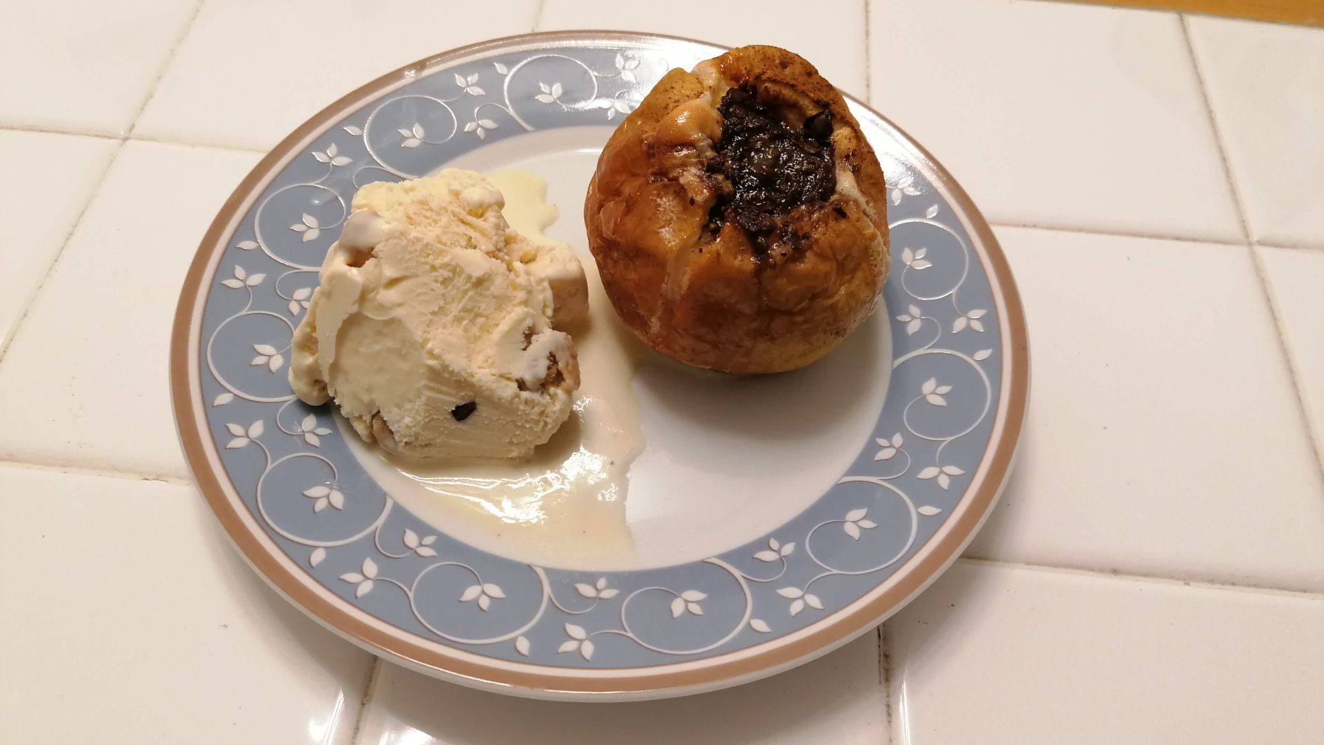 Bratapfel mit Vanillesoße auf einem Teller.