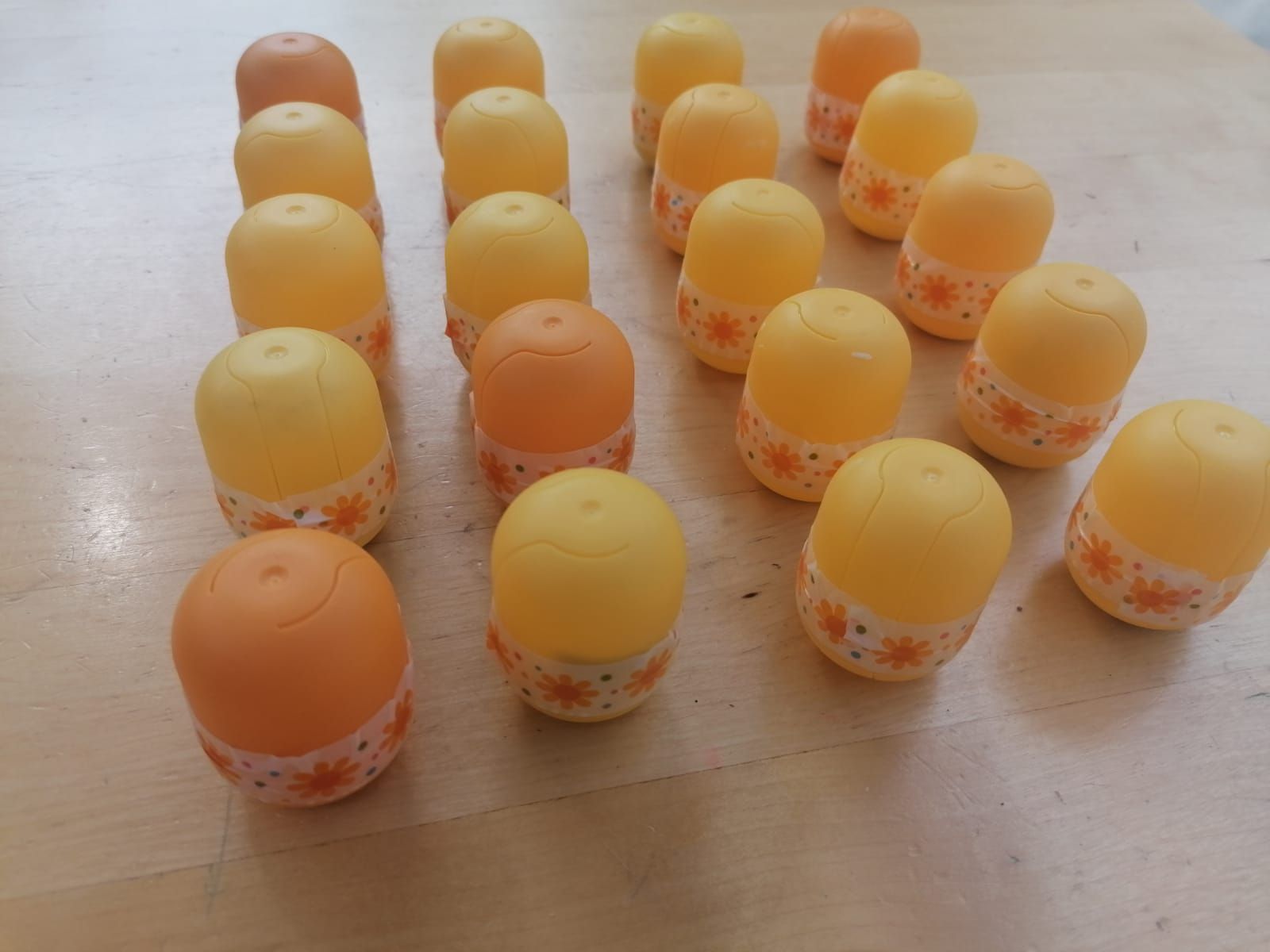 Auf dem Tisch stehen mehrere kleine, gelbe Verpackungen. Sie sind mit einem bunten Klebestreifen zugeklebt.