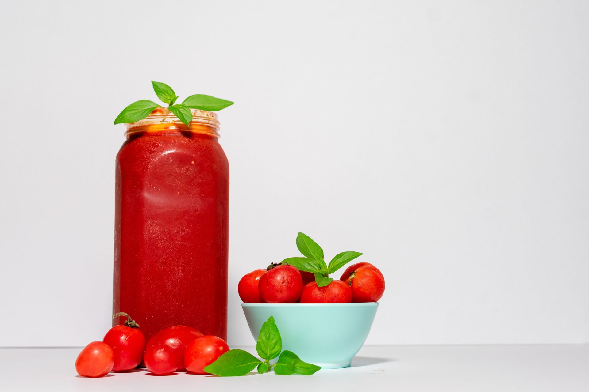 Ketchup im Glas und Schüssel mit Tomaten.