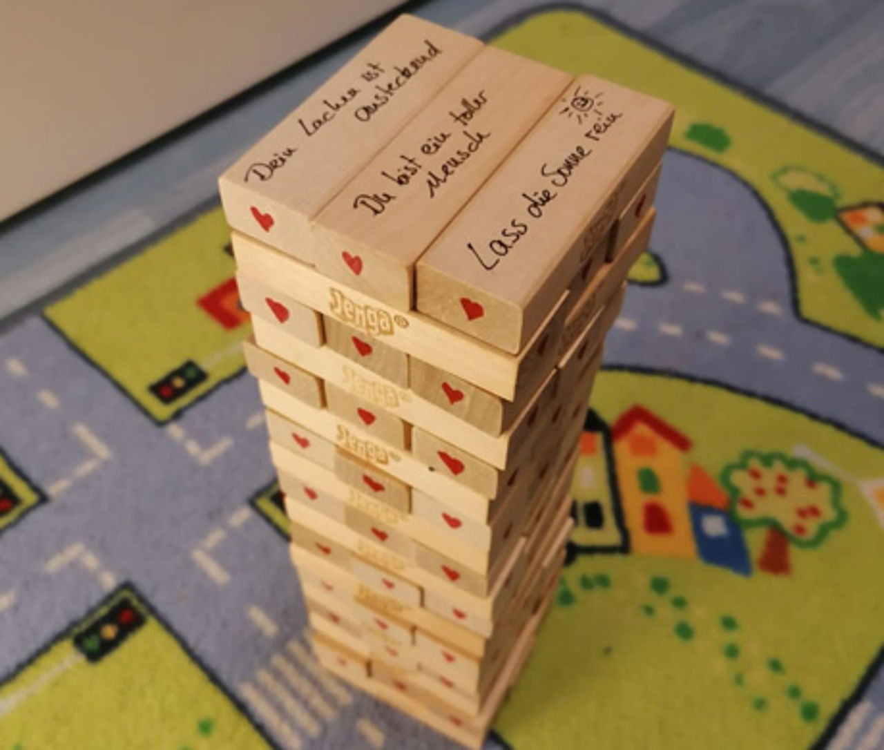 Jengaturm mit Komplimenten beschriftet.