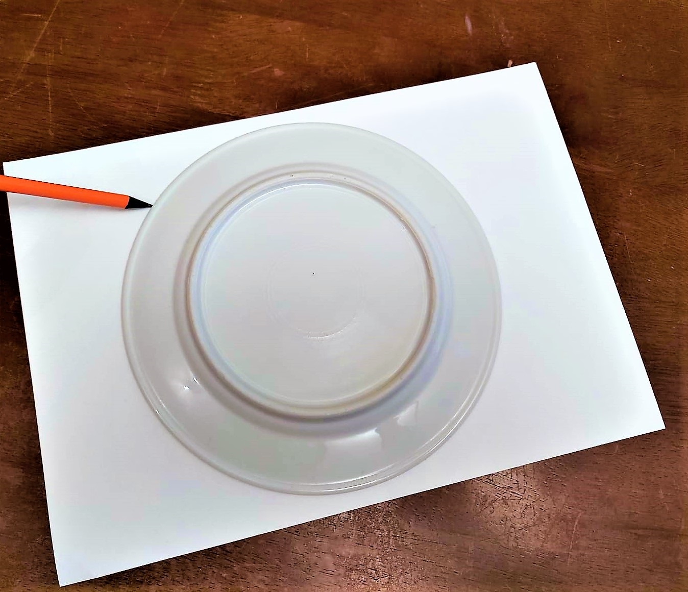 Ein Teller und ein Stift liegen auf einem Blatt Papier.
