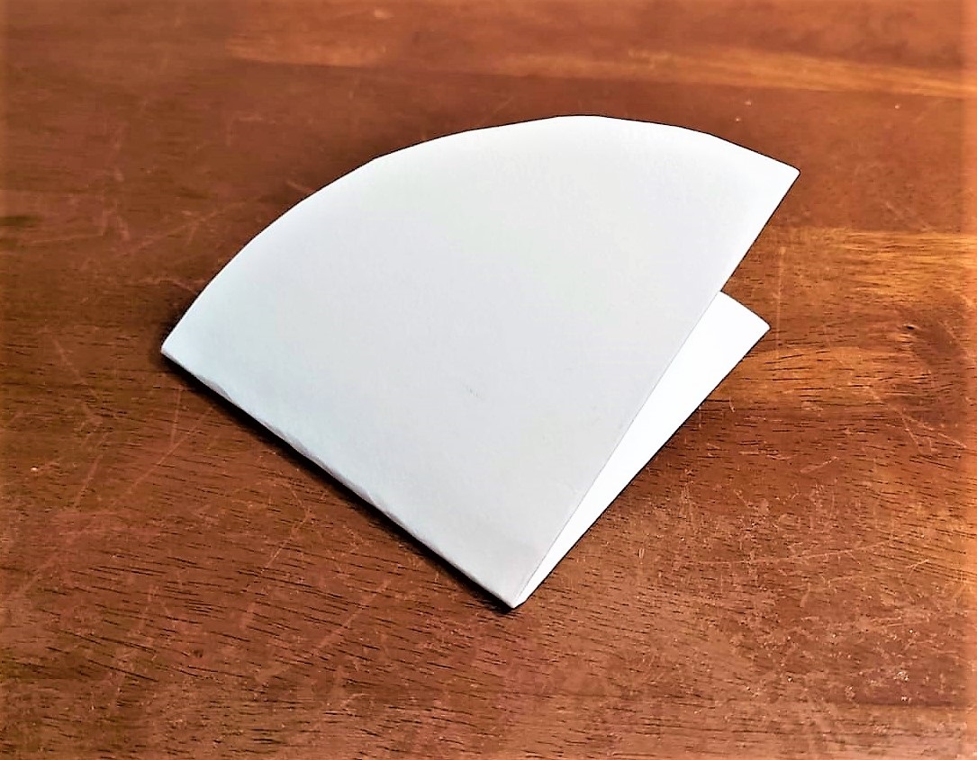 Ein gefaltetes Papier liegt auf dem Tisch.