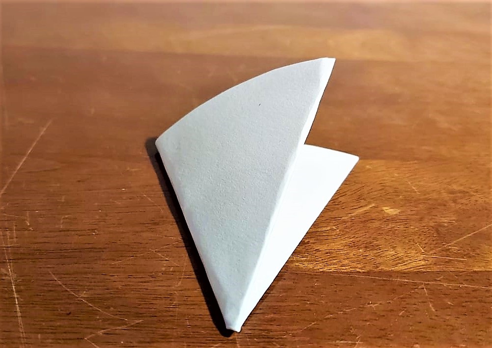 Ein gefaltetes Papier liegt auf dem Tisch.