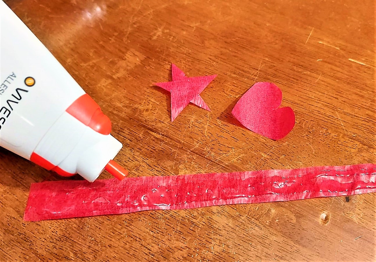 Kleber wird auf Transparentpapier aufgetragen.