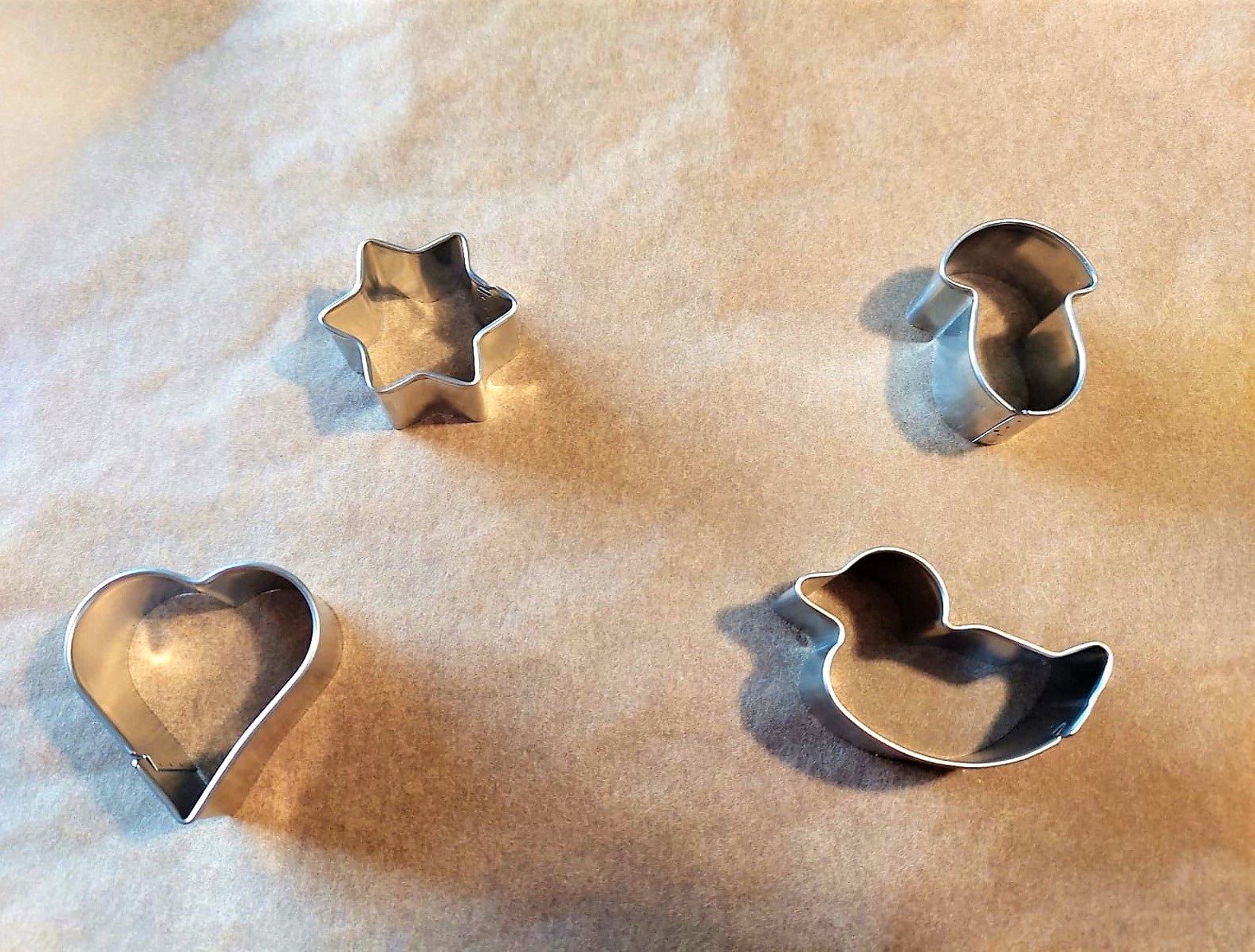 Ausstechformen liegen auf Backpapier.