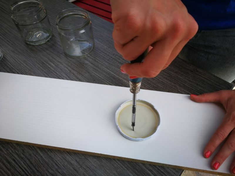 Ein Schraubdeckel wird auf einem Holzbrett befestigt.