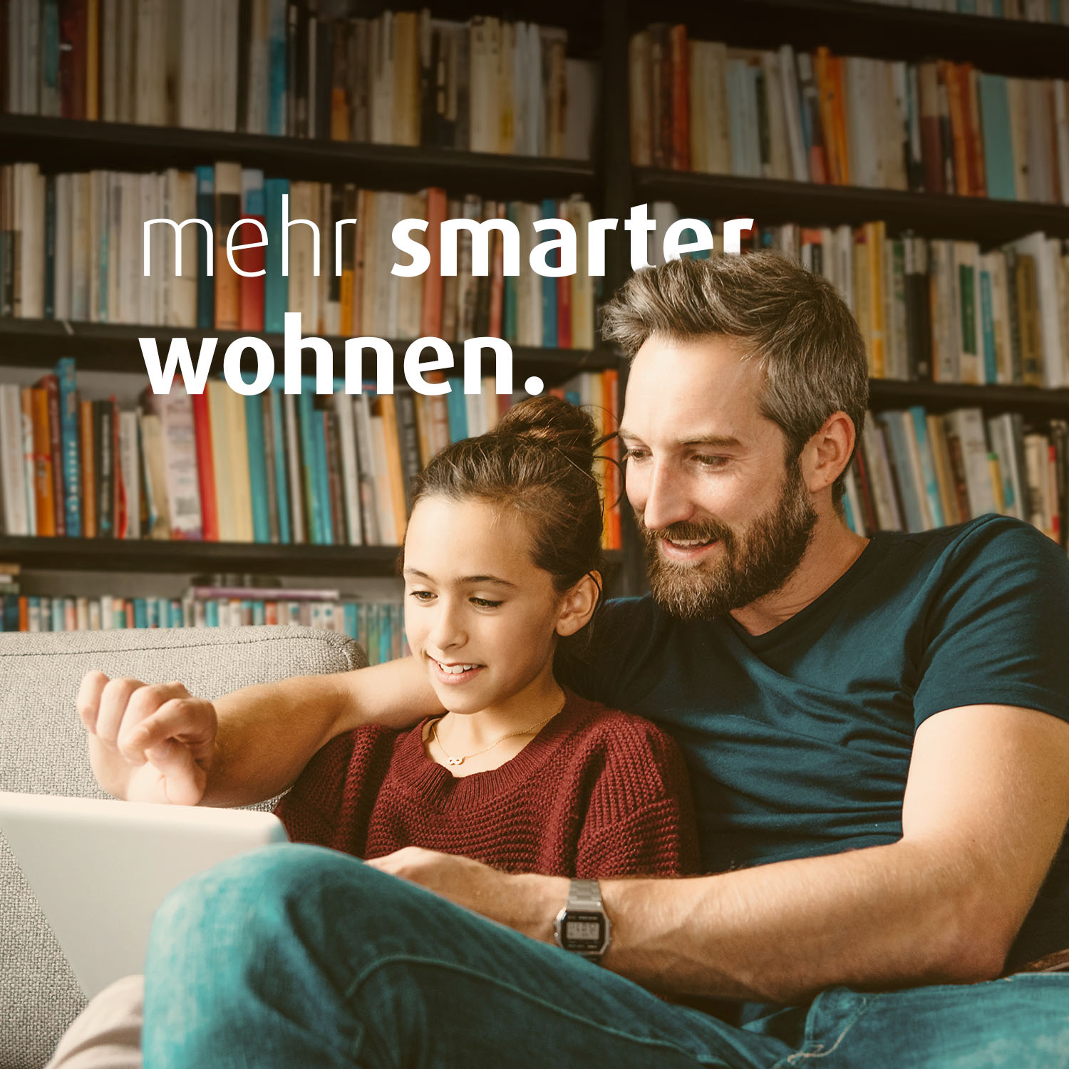 Ein Mann und ein Mädchen sitzen auf dem Sofa. Sie schauen zusammen auf ein Tablet. Auf dem Bild steht der Text "mehr smarter wohnen".