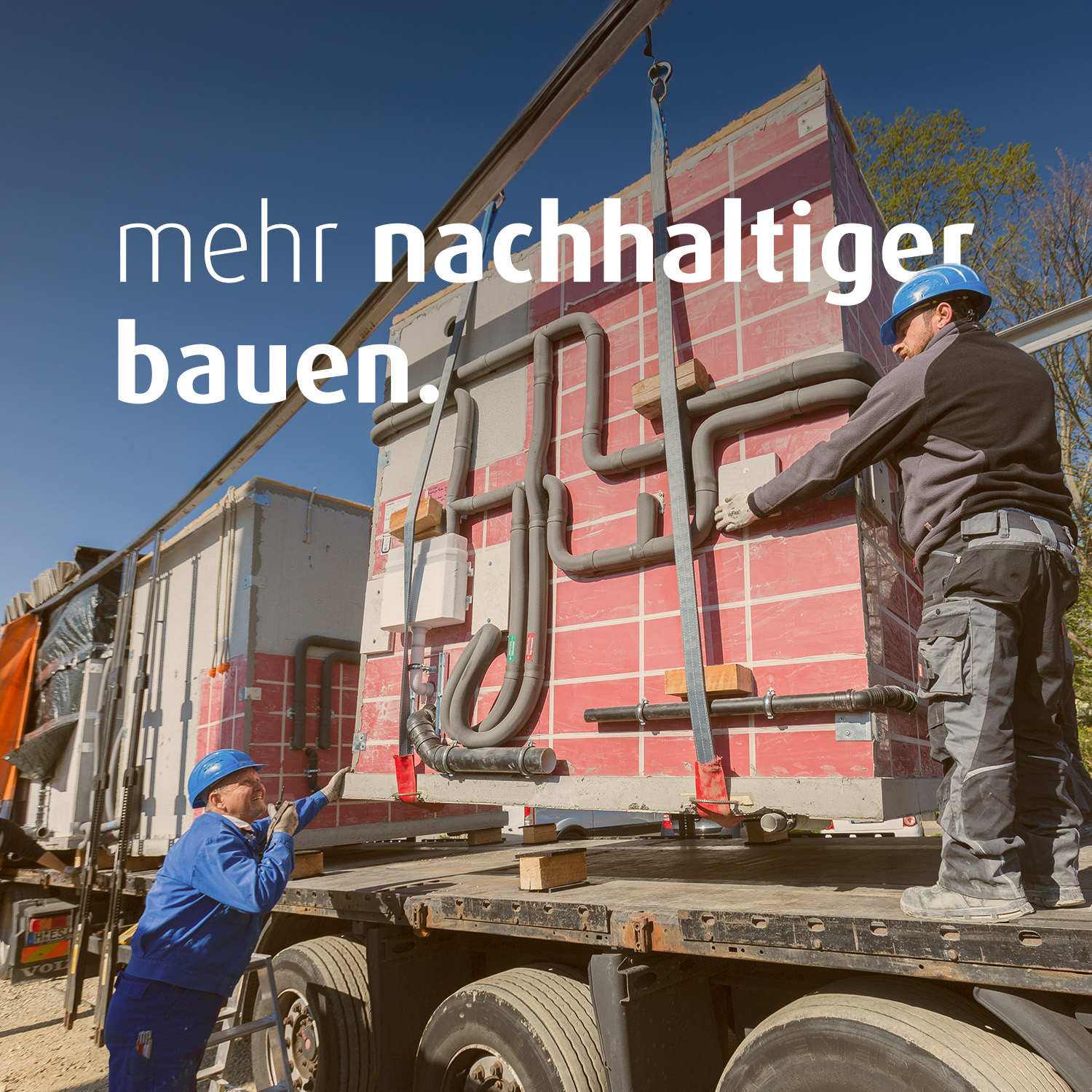 Zwei Männer in Baustellenkleidung entladen einen Lastwagen, der ein Modul für die Baustelle angeliefert hat. Auf dem Bild steht der Text "mehr nachhaltiger bauen".