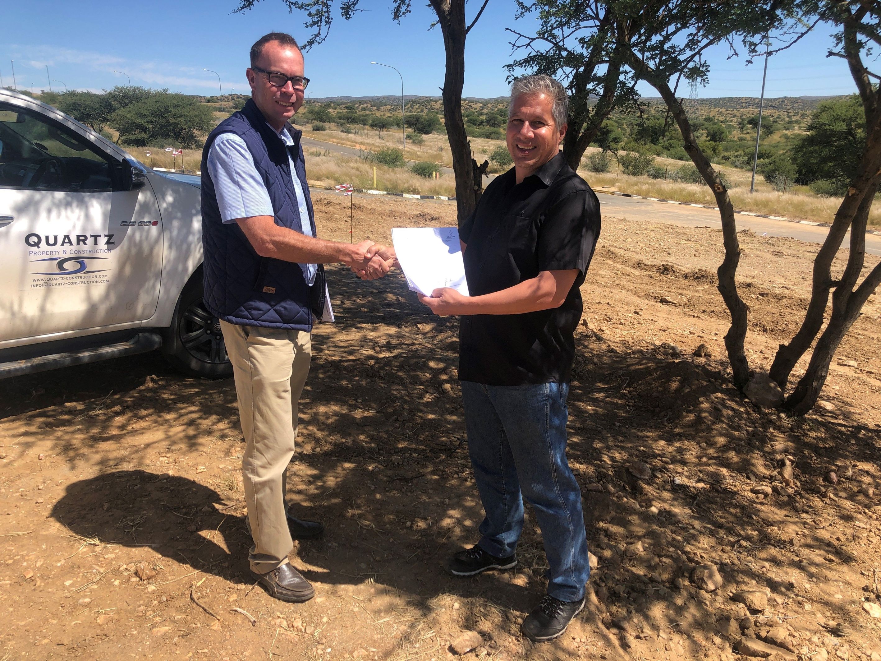 Zwei Männer halten ein Stück Papier