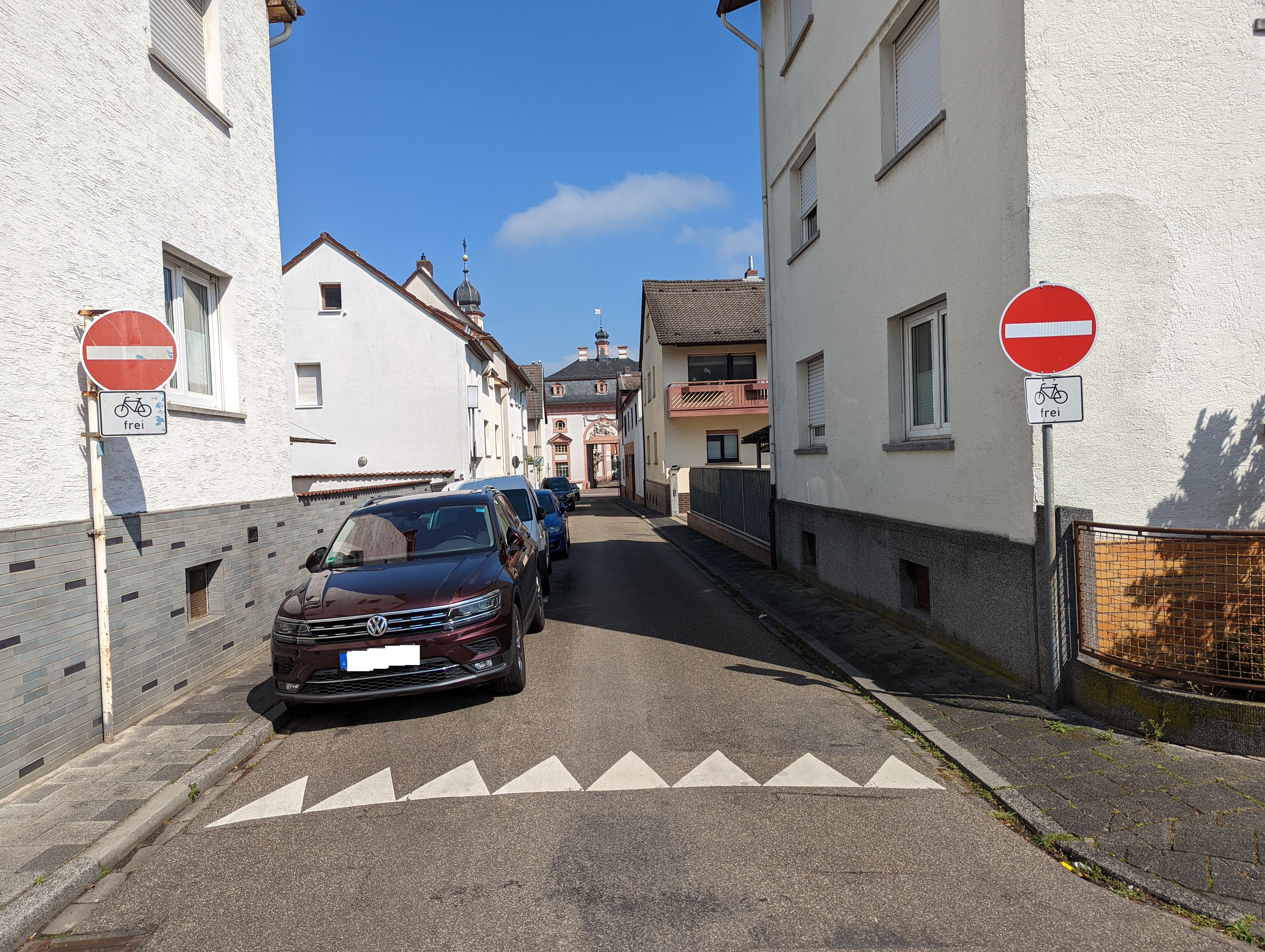 Auto in Straße und zwei Durchfahrt-Verboten-Schilder