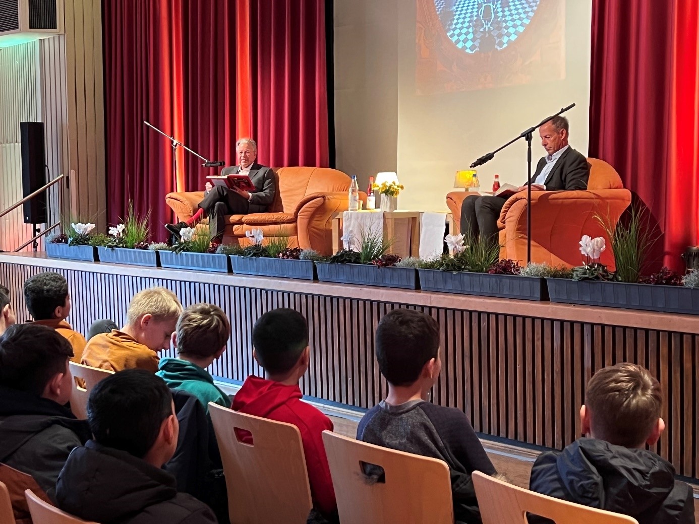  NHW-Geschäftsführer Dr. Constantin Westphal und Rüsselsheims Oberbürgermeister lesen Fünftklässlern vor.