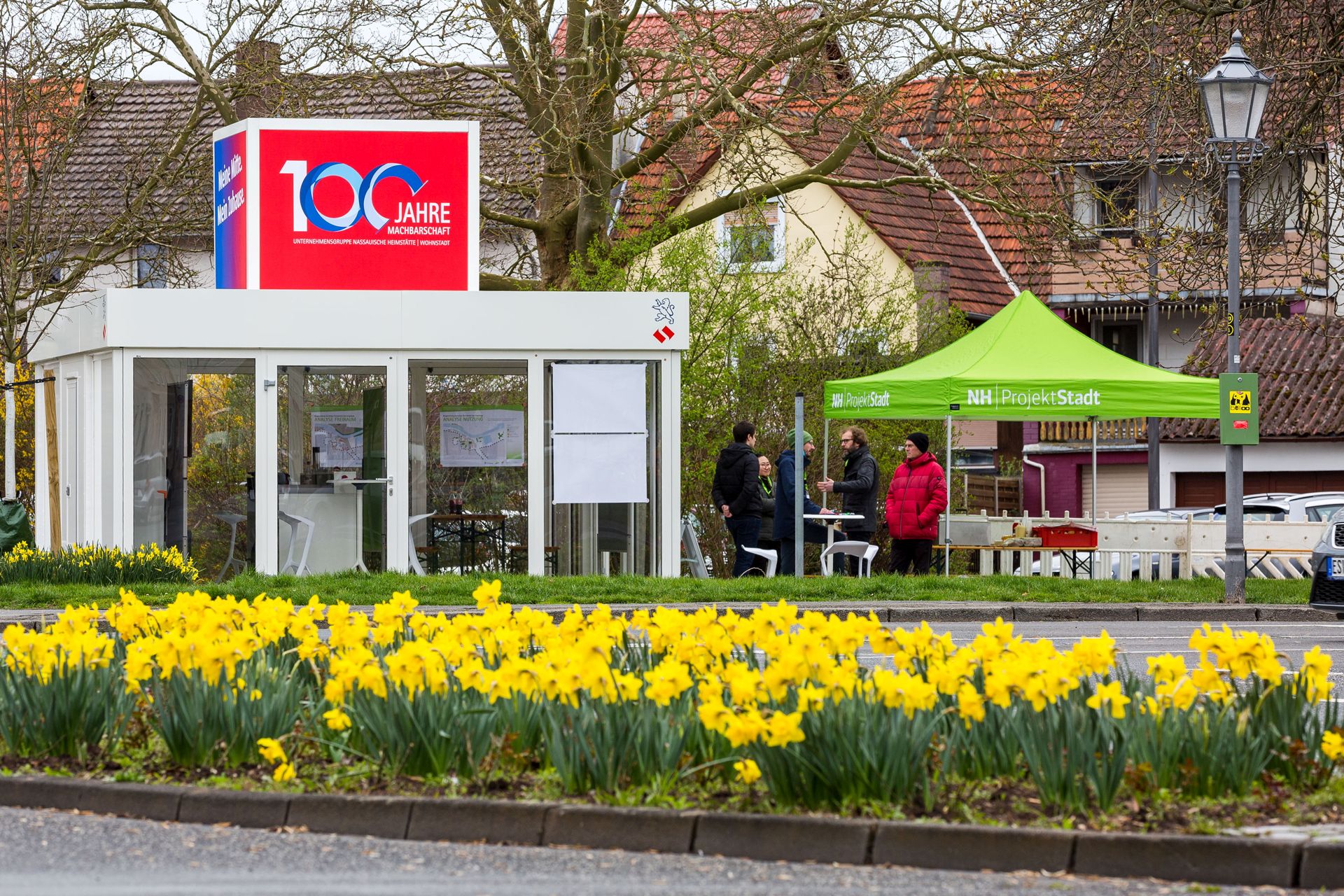 Der Info-Cube der NHW mit 100-Jahre-Logo und ein Stand der ProjektStadt