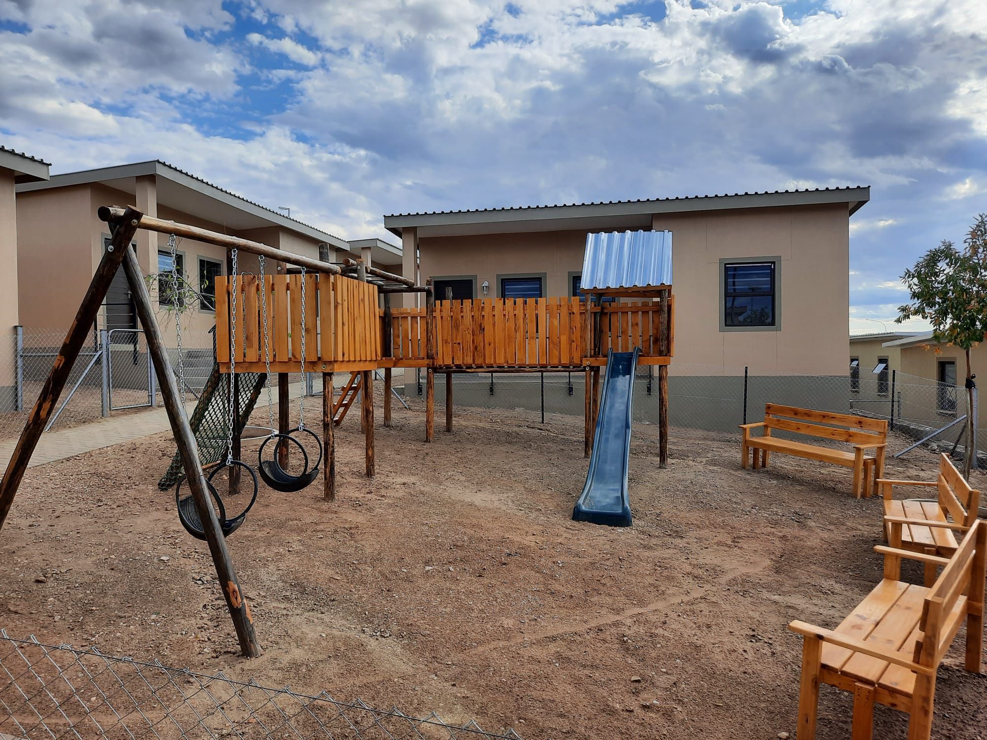 Kinderspielplatz und Sitzgelegenheiten vor den neuen Häusern