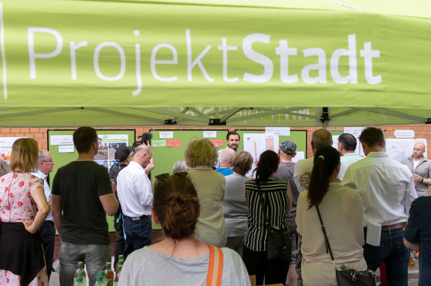Menschenansammlung vor ProjektStadt-Banner