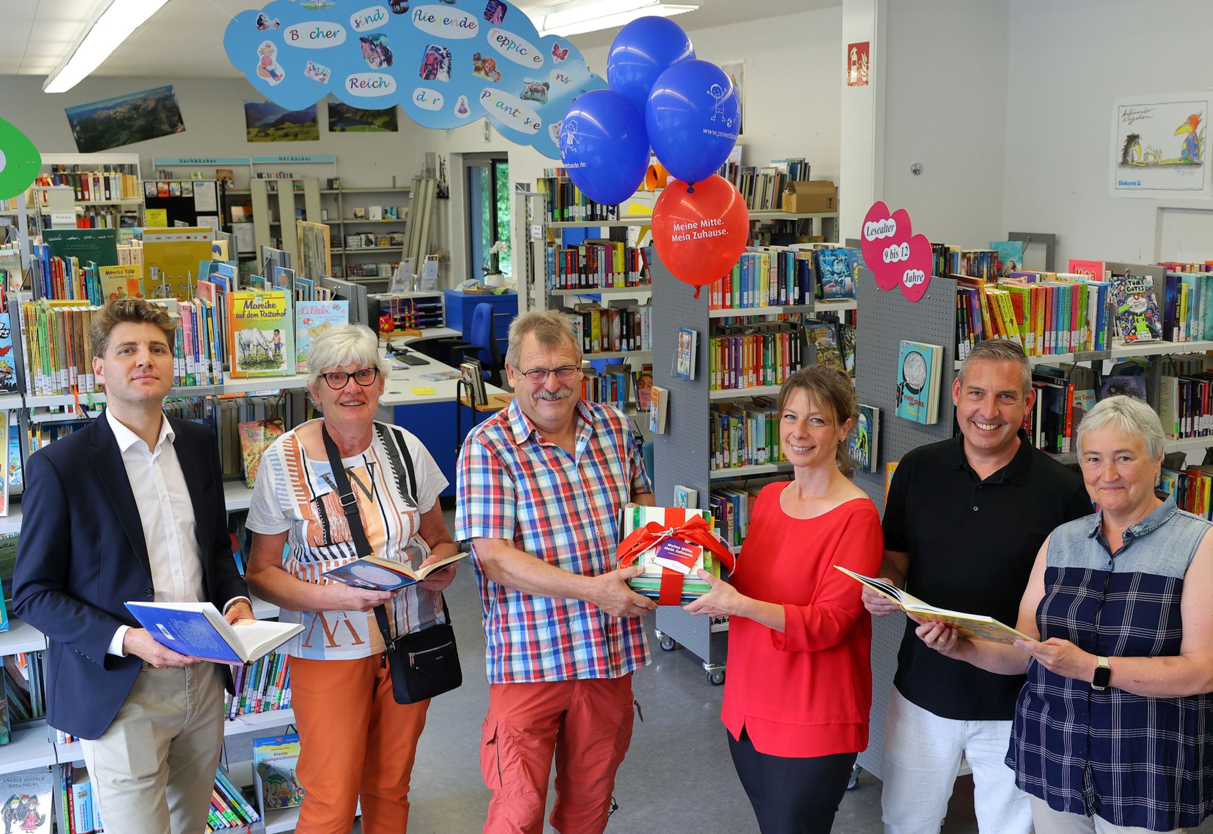 (v. l.) Alexander Hauschild (Projektleiter Sozialmanagement, NHW), Heidrun Trapp (Vorständin Stadtteilbücherei Fasanenhof e. V.), Wolfgang Trapp (Vorstand Stadtteilbücherei Fasanenhof e. V.), Jennifer Linke (Projektleiterin Sozialmanagement, NHW), Sascha Holstein (Leiter Regionalcenter Kassel, NHW), Elke Ebert (Vorständin Stadtteilbücherei Fasanenhof e. V.) übergeben die Bücherspende. 