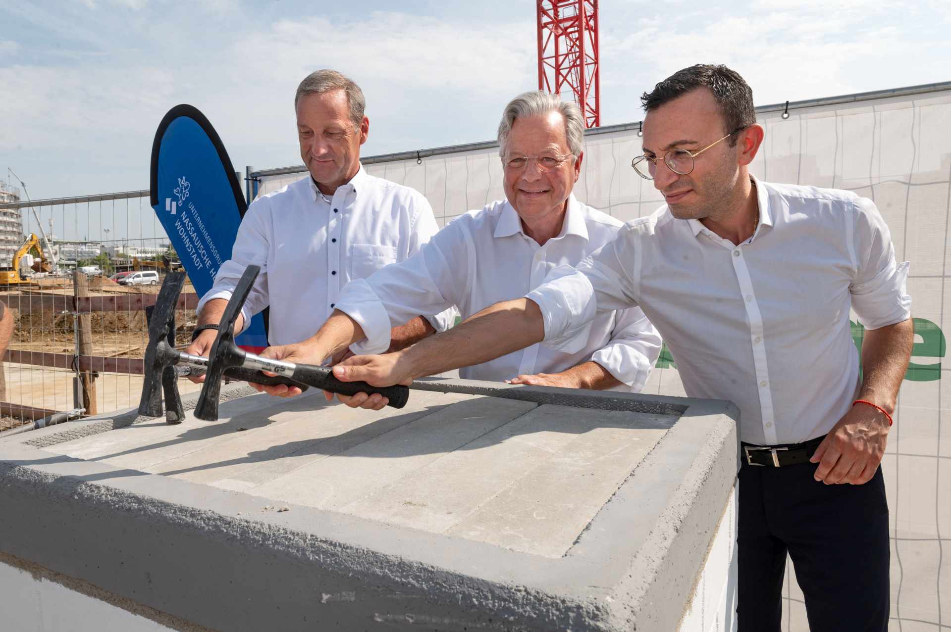 Haben gemeinsam den  Hammer in die Hand genommen: (v.l.) Frank Zschippig Technischer Leiter WGF Weisenburger bau GmbH, NHW-Geschäftsführer Dr.Constantin Westphal und Oberbürgermeister Mike Josef. Foto: NHW/Strohfeld