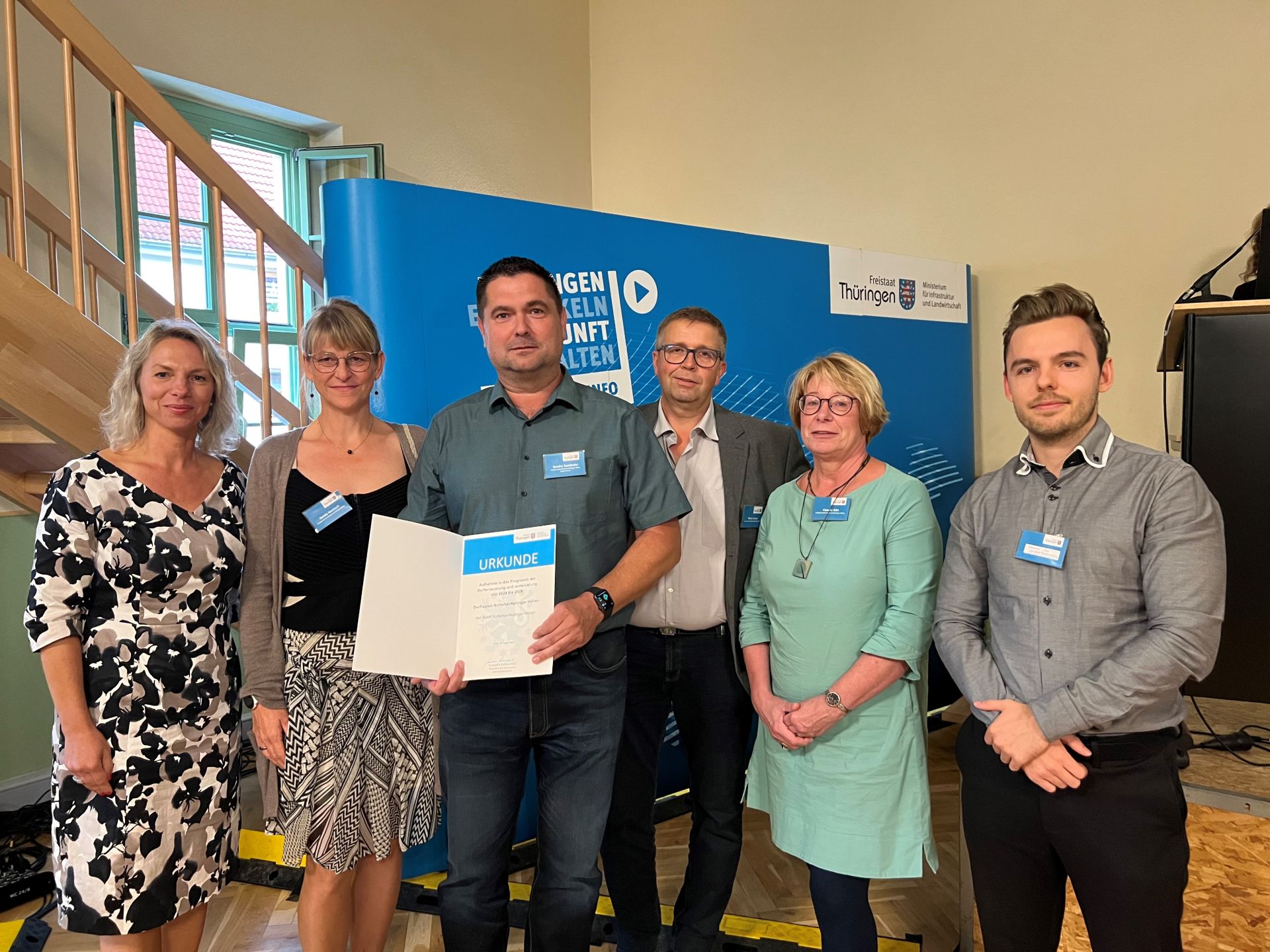 Übergabe der Urkunde für die Landgemeinde Nottertal-Heilinger Höhen: (v. li.) Ministerin Susanna Karawanskij, Sandy Harnisch (Mitarbeiterin Verwaltung), Sandro Seeländer (stellvertretender Bürgermeister), Marko Hesse (Vorsitzender Dorfentwicklungsbeirat), Claudia Görl (Mitarbeiterin Verwaltung) und Dominic Otto (Projektmitarbeiter ProjektStadt).