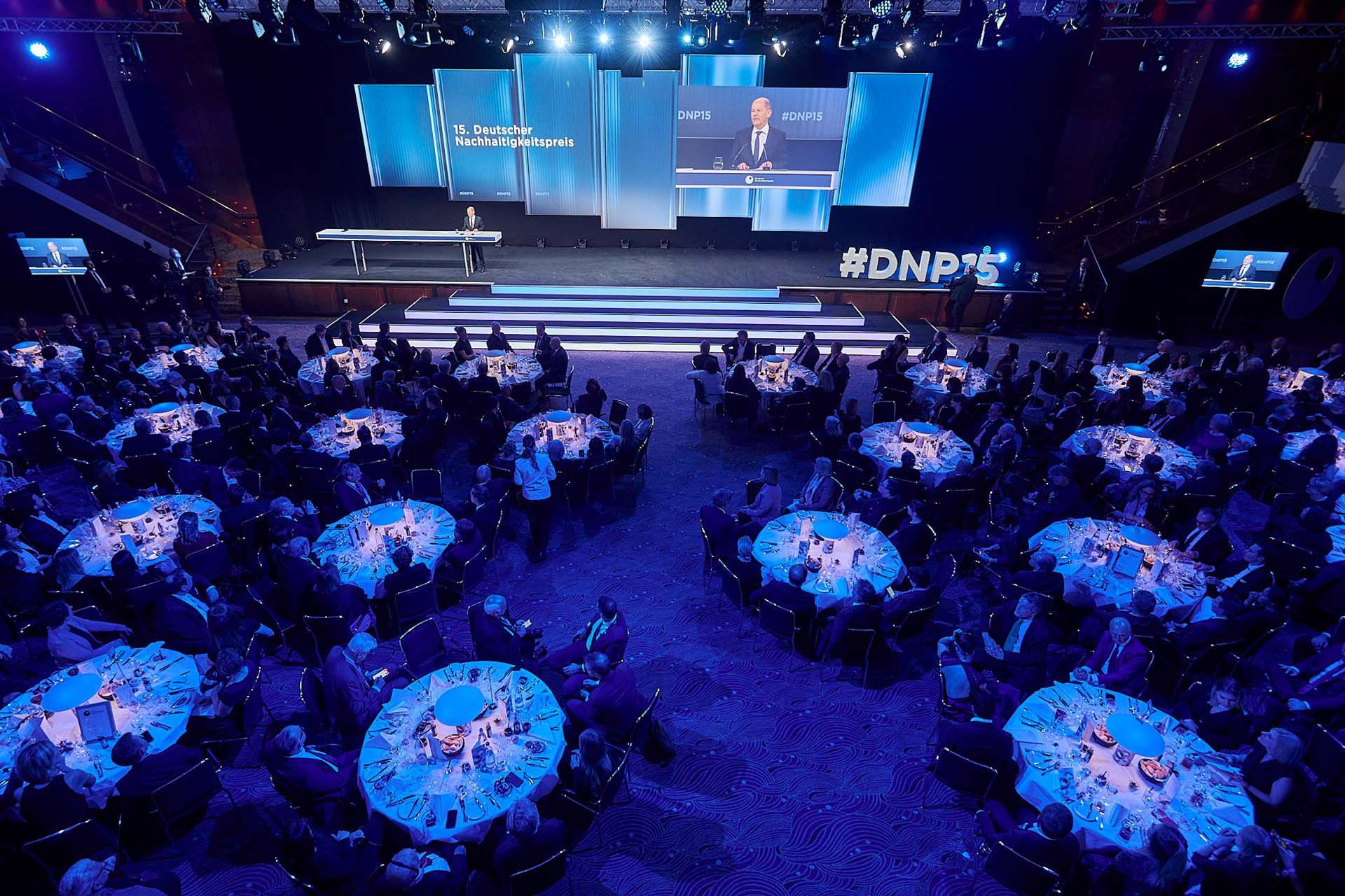 Viele runde Tische in blaues Licht getaucht, Verleihung des DNP 2022