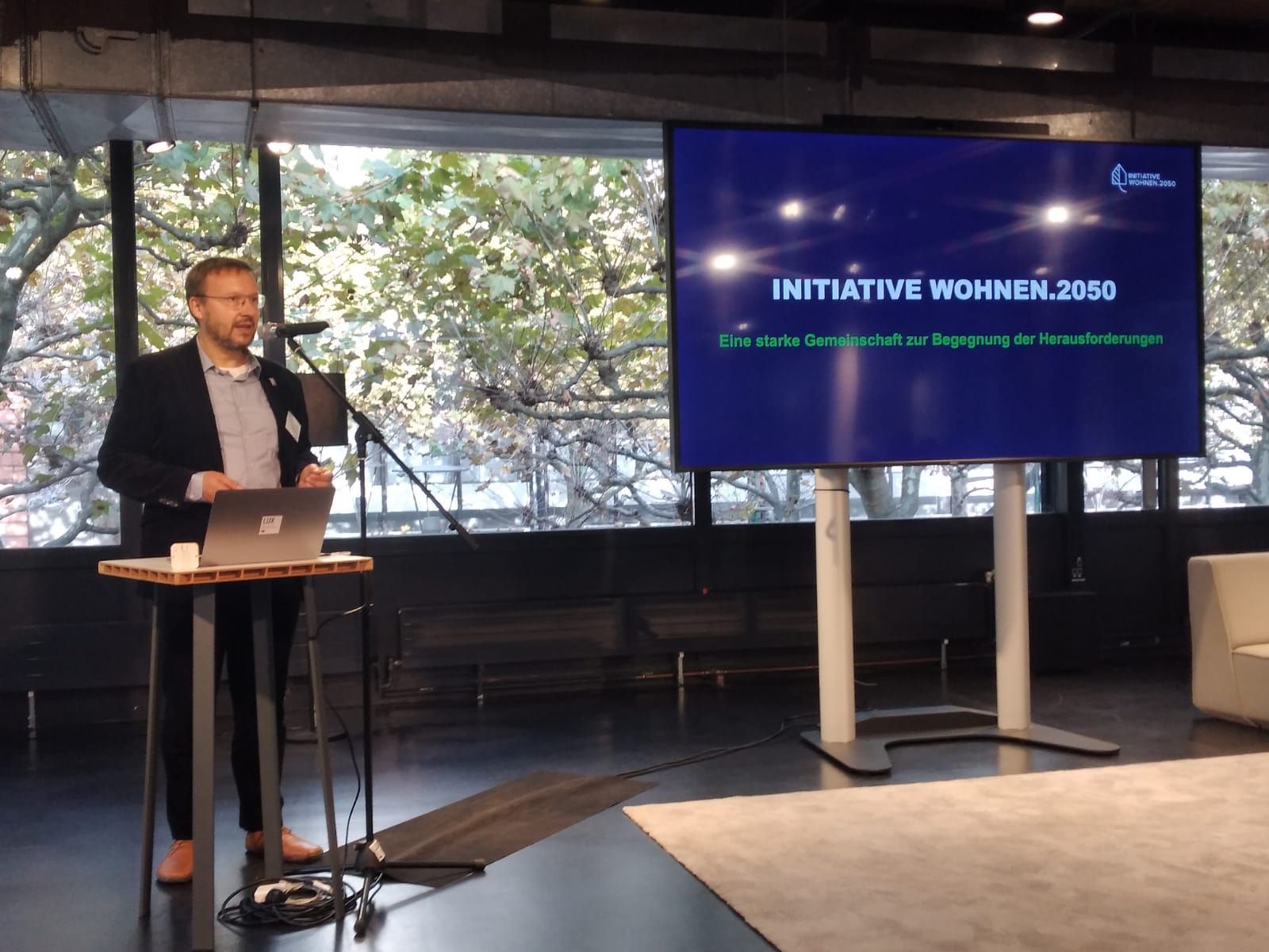 Felix Lüter spricht in ein Mikrofon, daneben ein Screen mit Infos zur IW.2050