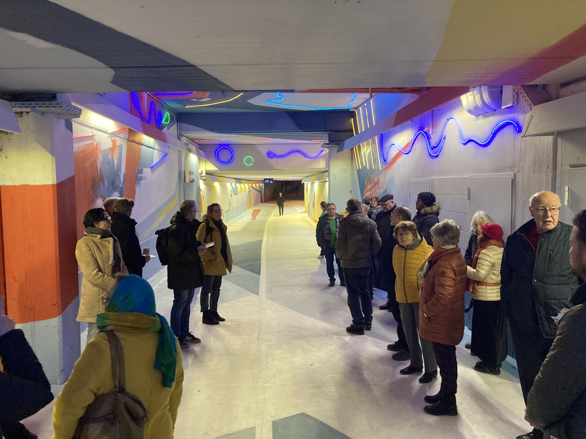 Rund 30 Menschen in der neu gestalteten, mit bunten Lichtern versehenen Kelsterbacher S-Bahn-Unterführung.