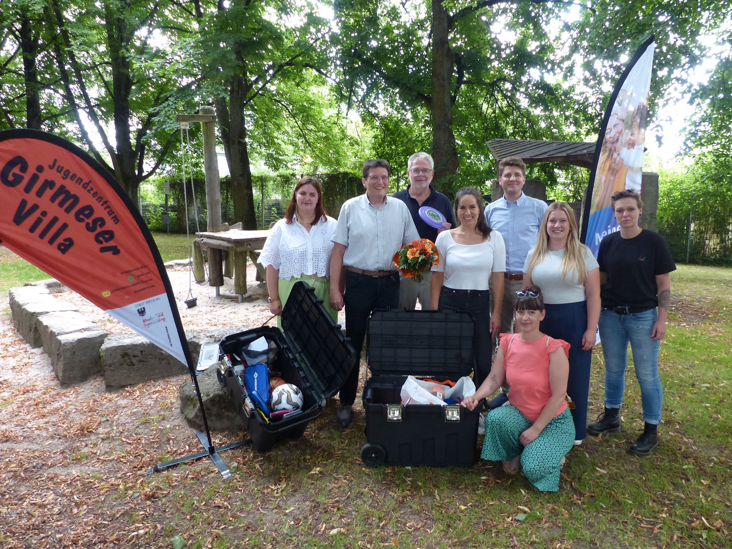 NHW-Servicecenterleiter Hendrik Hoekstra (3. v. li.), Alexander Hauschild von der Sozialen Quartiersentwicklung der NHW (3. v. re.) und Kundenmanagerin Janina Müller (4. v. li.) übergeben die Spende an Bürgermeister Dr. Andreas Viertelhausen (2. v. li.) sowie Vertreterinnen der Abteilung Kinder- und Jugendbildung der Stadt Wetzlar, des Quartiersmanagements und der Gemeinwesenarbeit.
