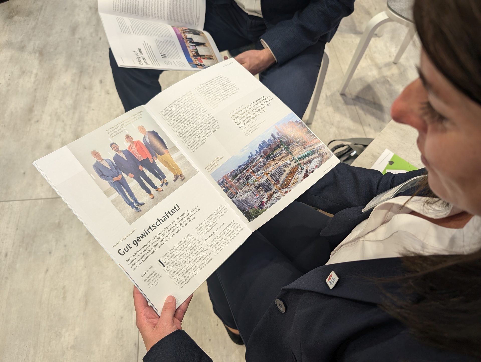 Eine Frau betrachtet die aufgeschlagenen Seiten eines Magazins.