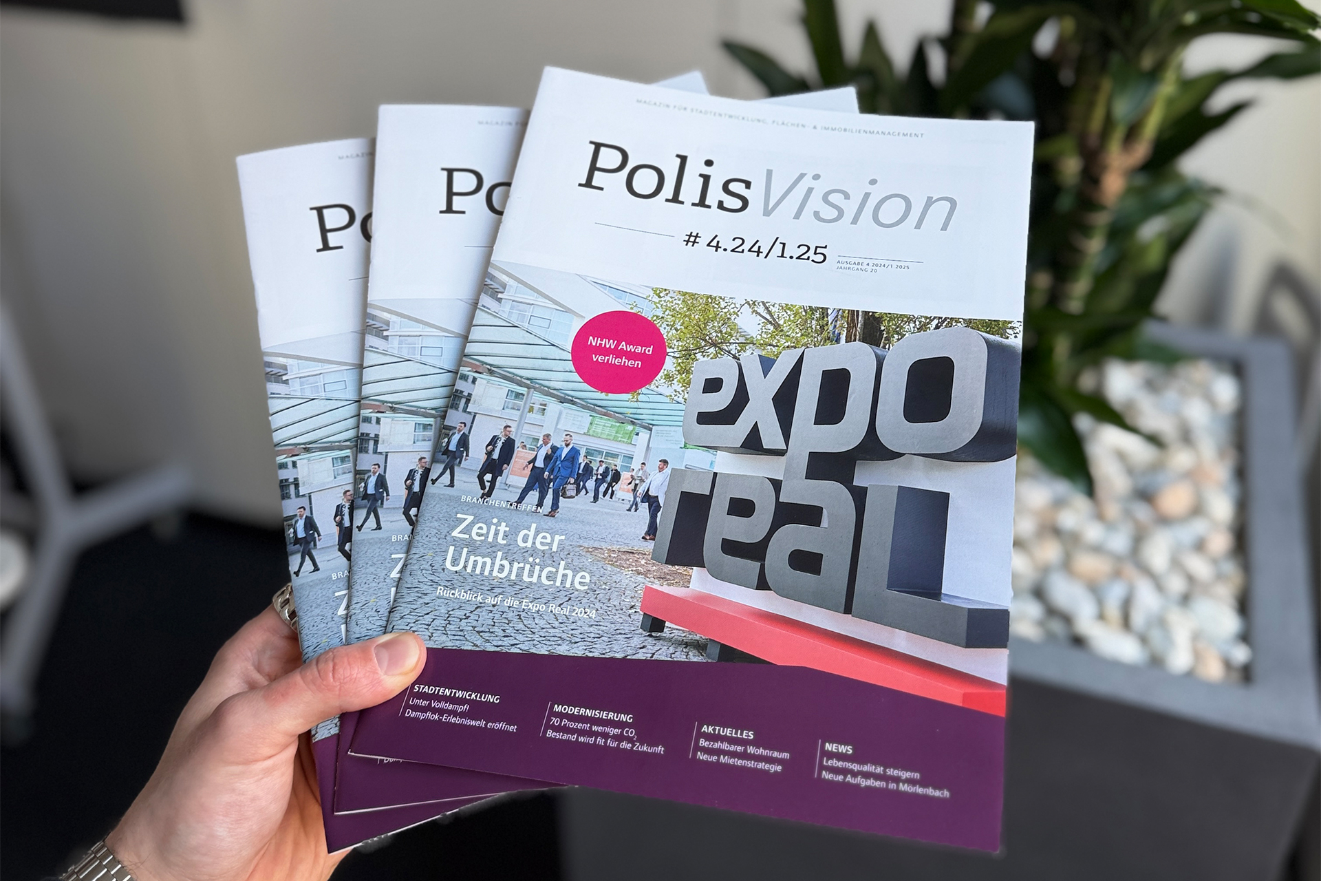 Drei gestaffelte PolisVision-Ausgaben vor einer Pflanze.