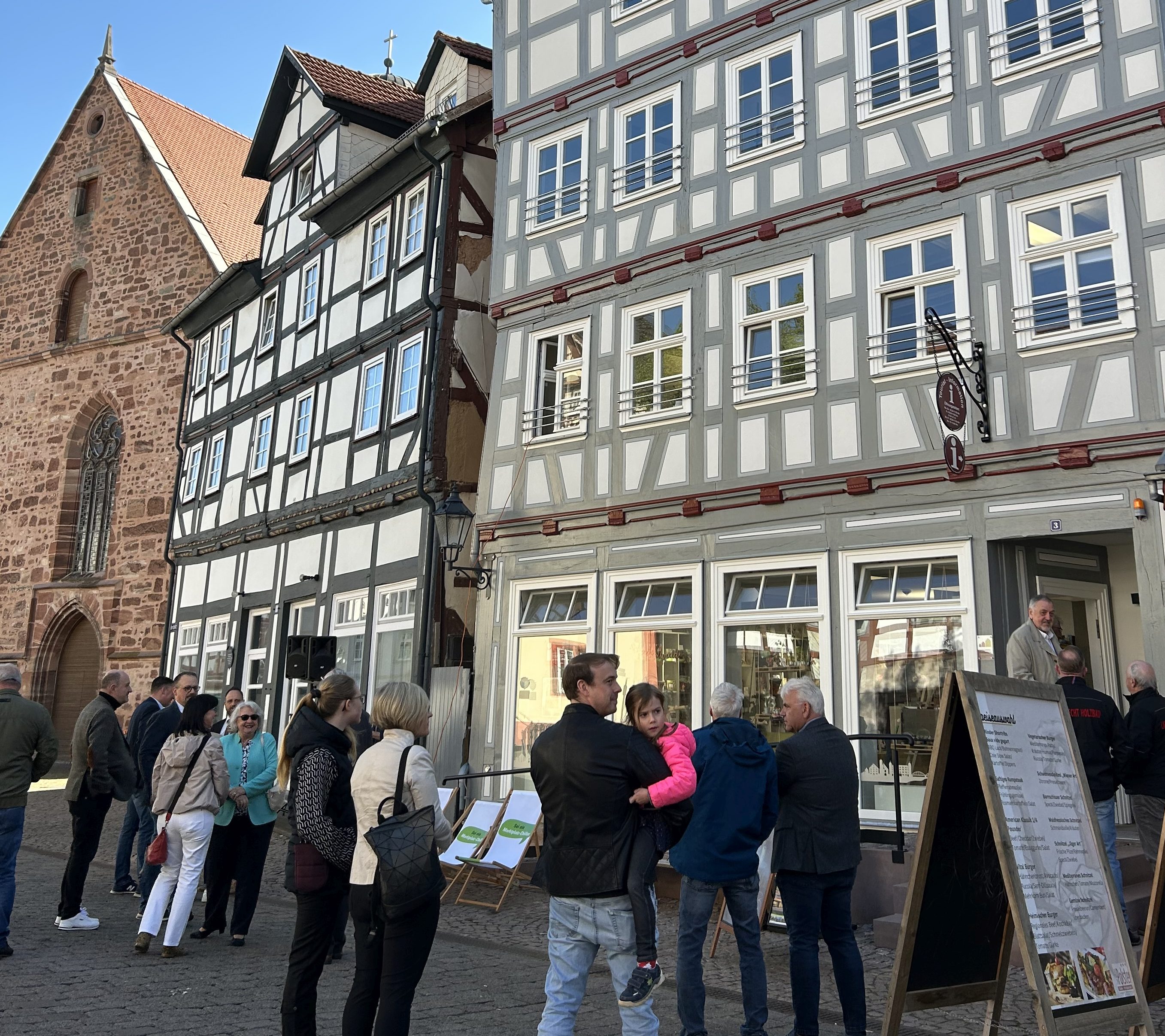 Mehrere Menschen vor einer schönen restaurierten Fachwerkkulisse in Rotenburg an der Fulda