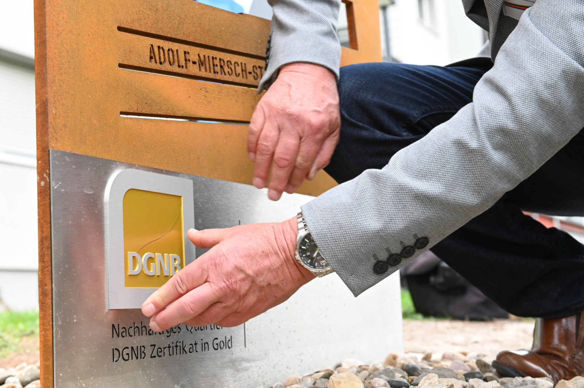 Hand befestigt DGNB-Plakette an Tafel