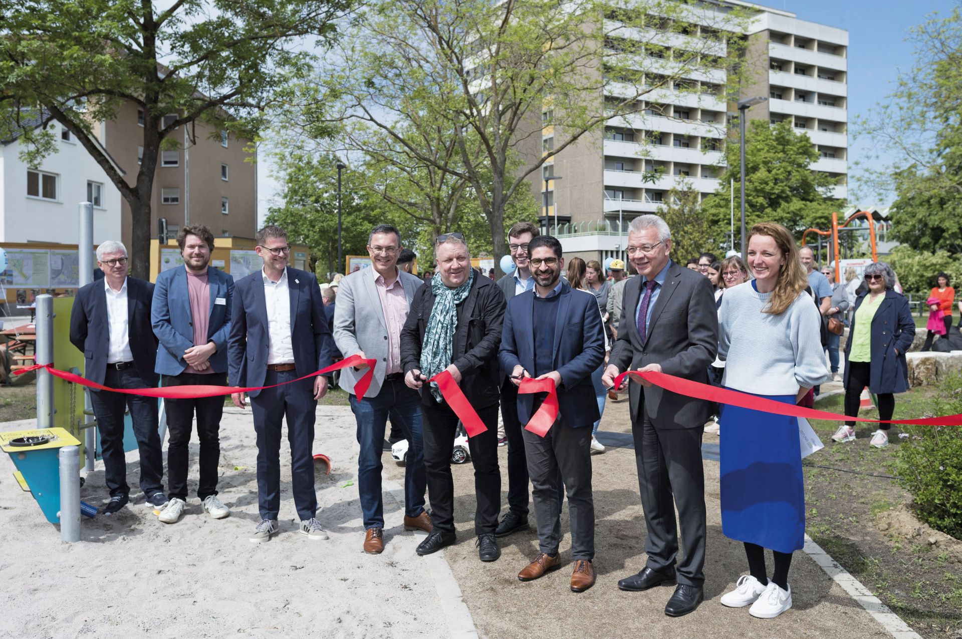 Minister Kaweh Mansoori und Bürgermeister Gottfried Störmer schneiden das rote Band durch. Neben ihnen stehen weitere Menschen.