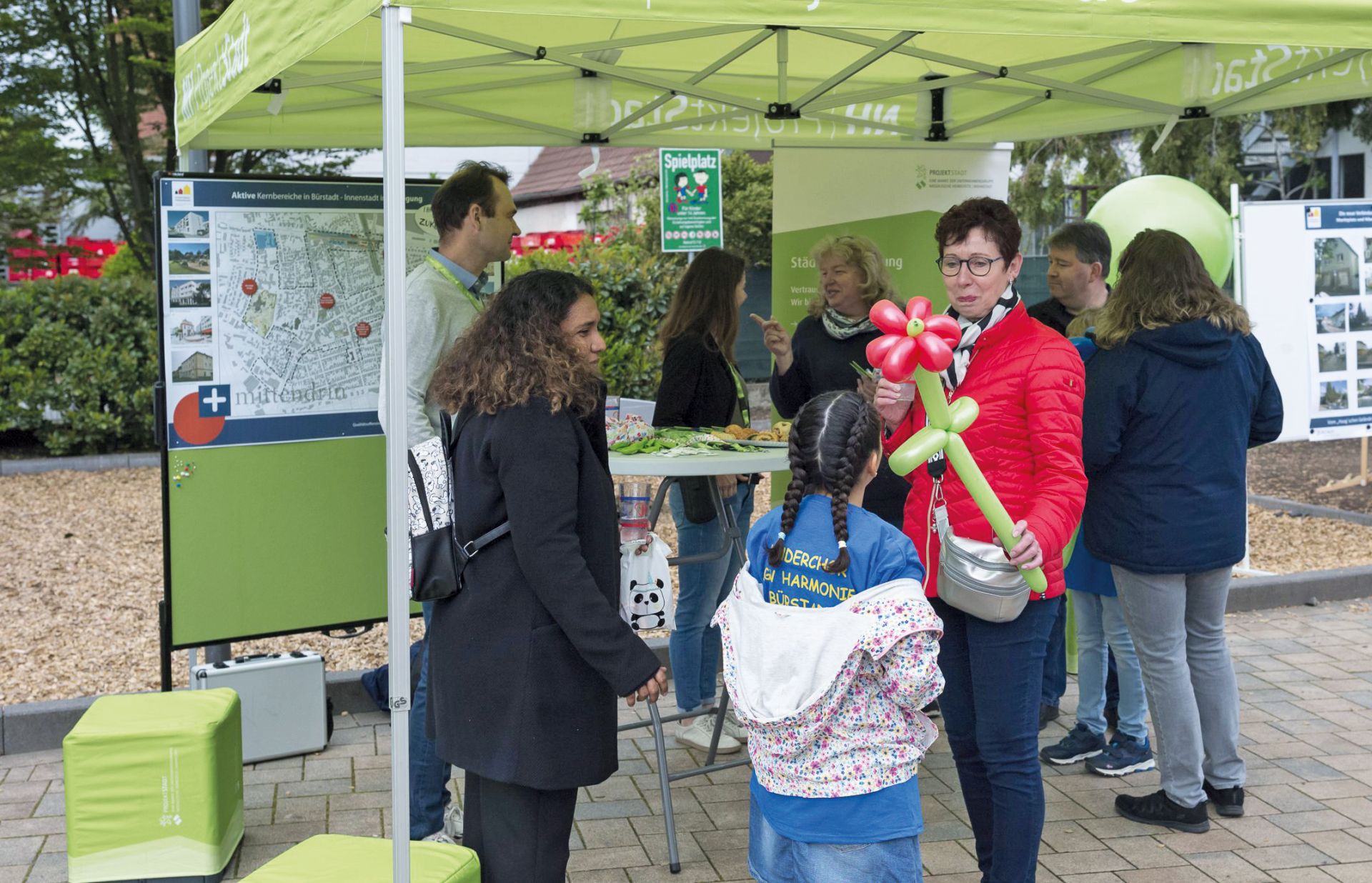 An einem Stand der Projektstadt werden Ballon-Tiere verteilt.
