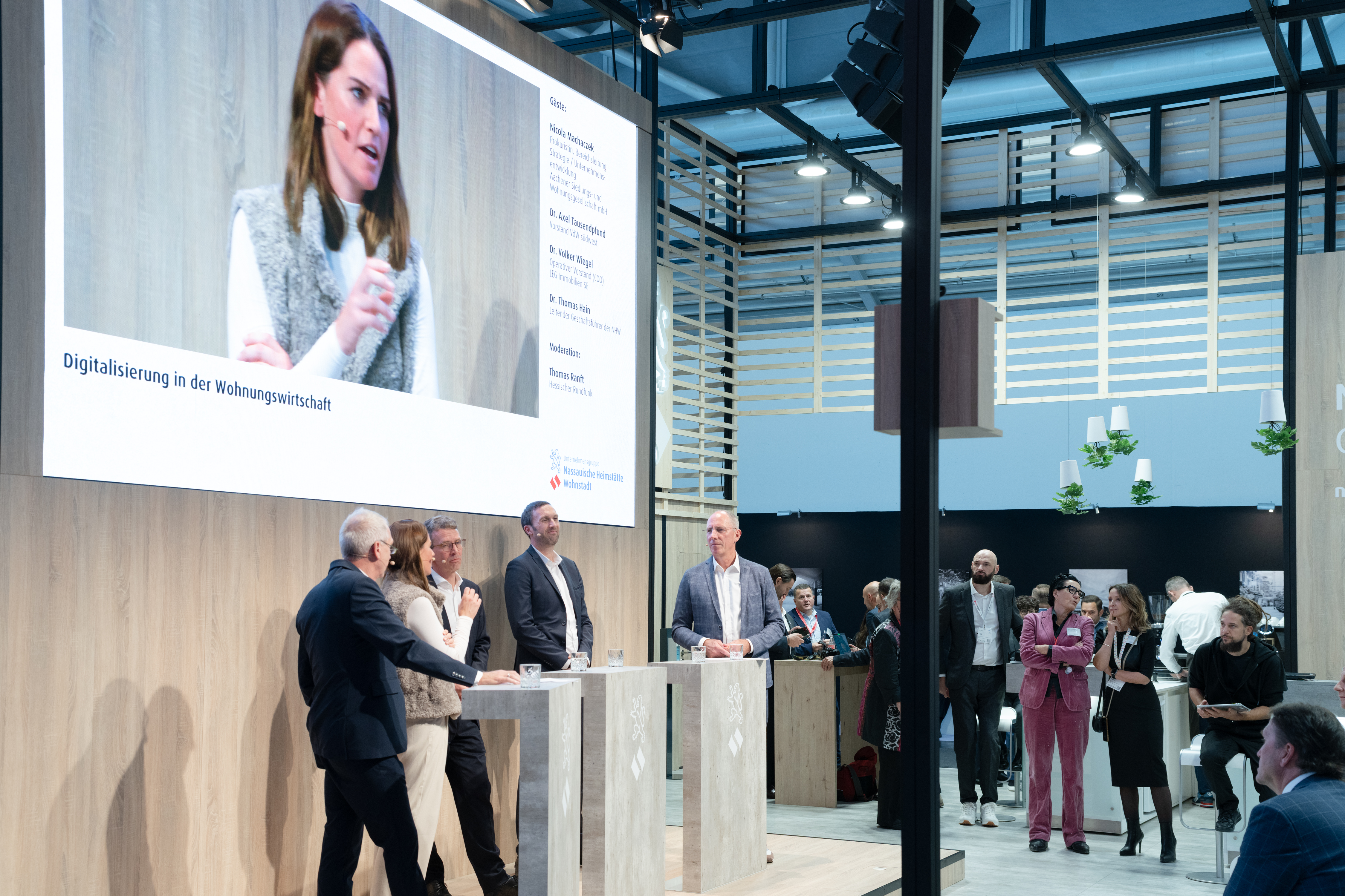 Teilnehmer der Podiumsdiskussion "Digitalisierung in der Wohnungswirtschaft" am NHW-Stand mit Moderator Thomas Ranft