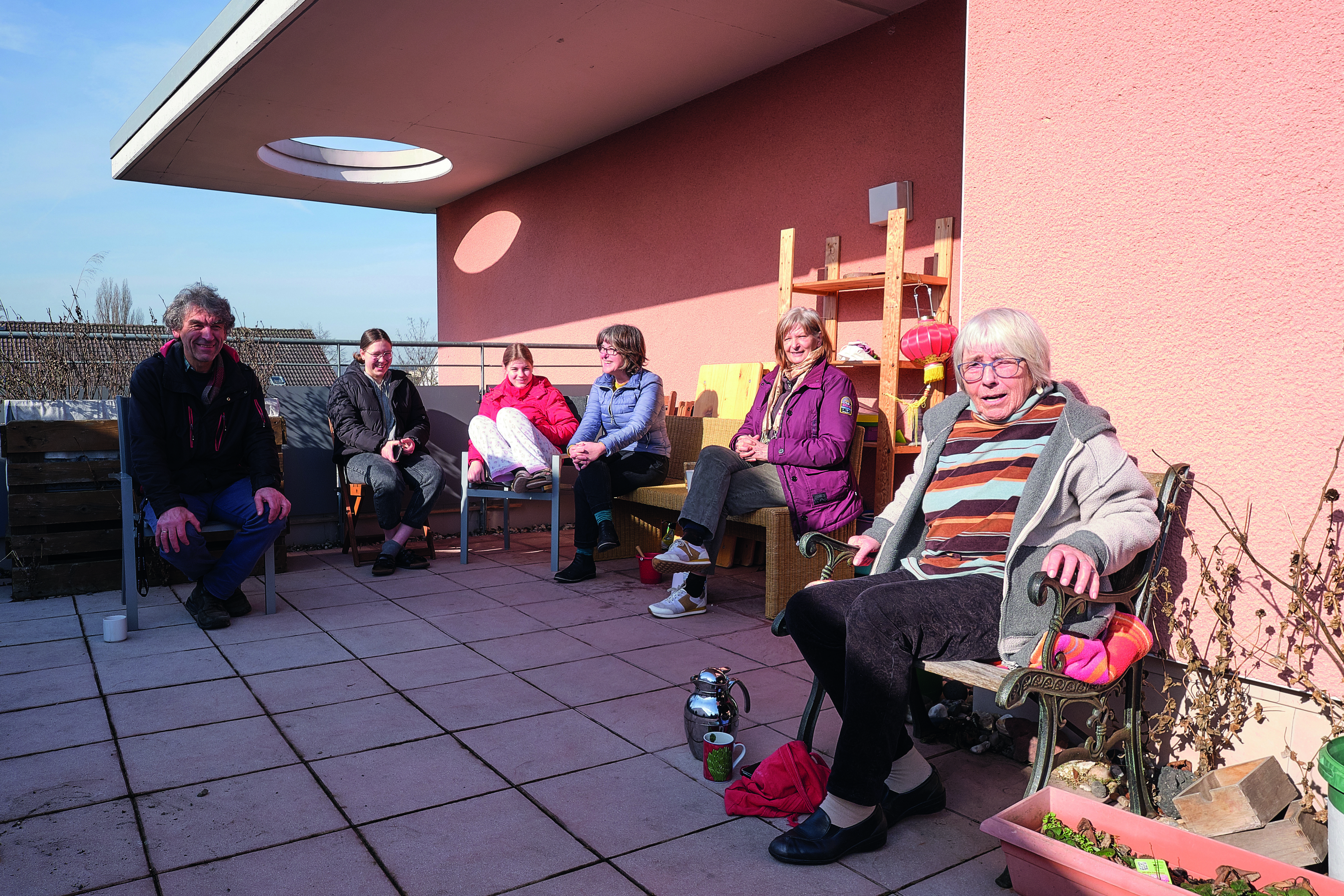 Gruppe von Personen sitzt auf einer Terrasse