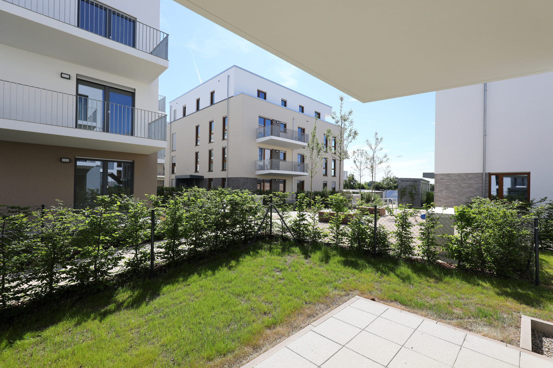 Blick von einer Terrasse in den Innenhof von einem Neubaugebiet.