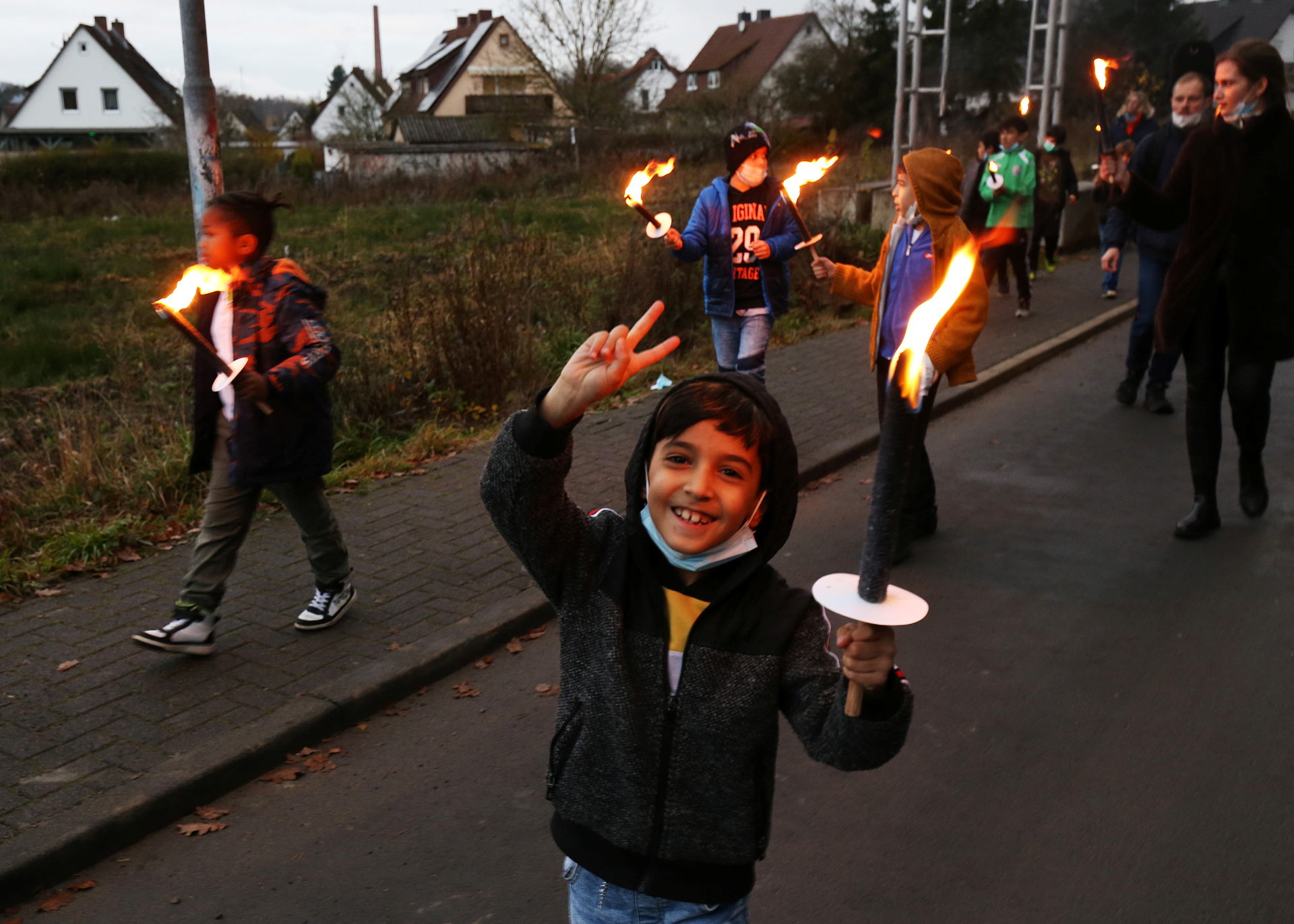 Kind mit Fackel schaut glücklich in die Kamera.