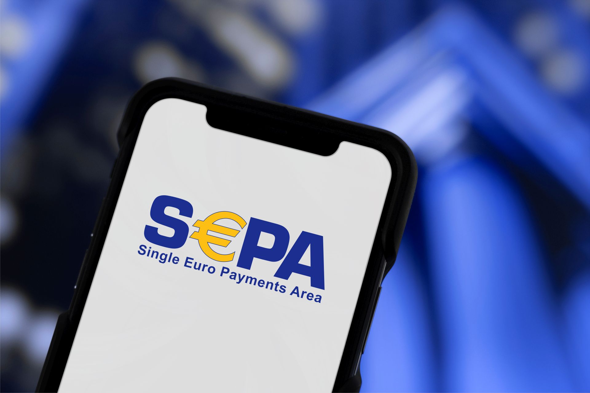 Auf dem Bild ist ein Smartphone mit dem Schriftzug SEPA zu sehen. Der Hintergrund ist blau.